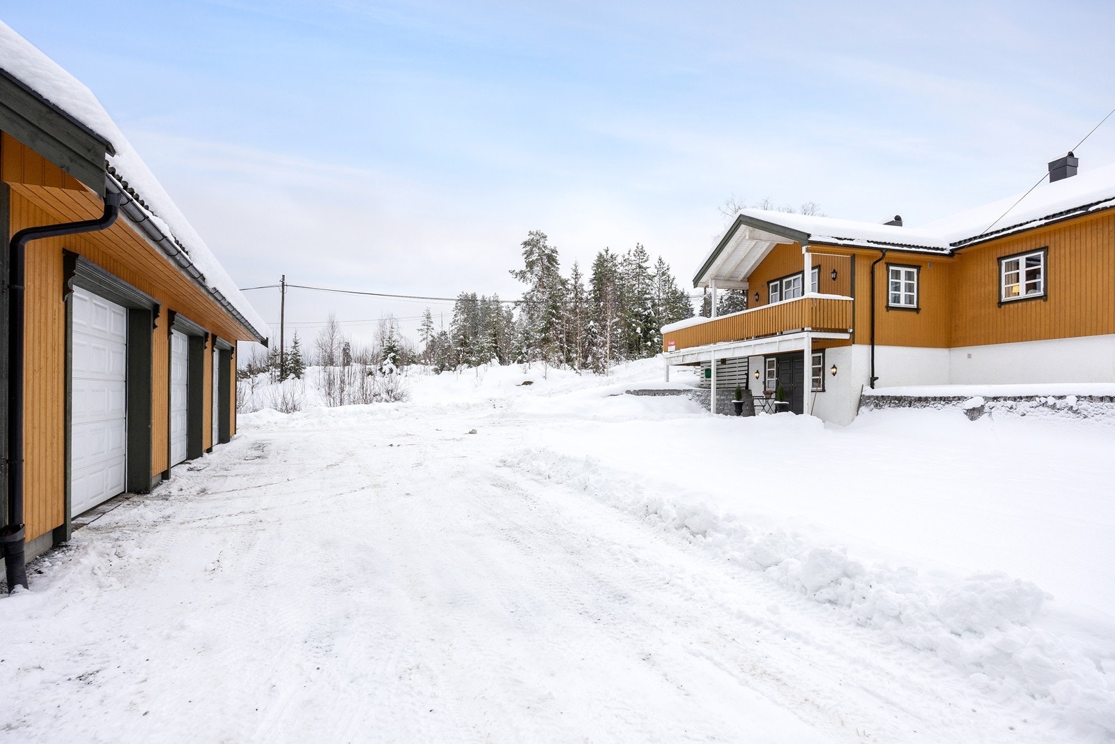 En gruslagt gårdsplass binder huset sammen med garasjen. Galleribilde