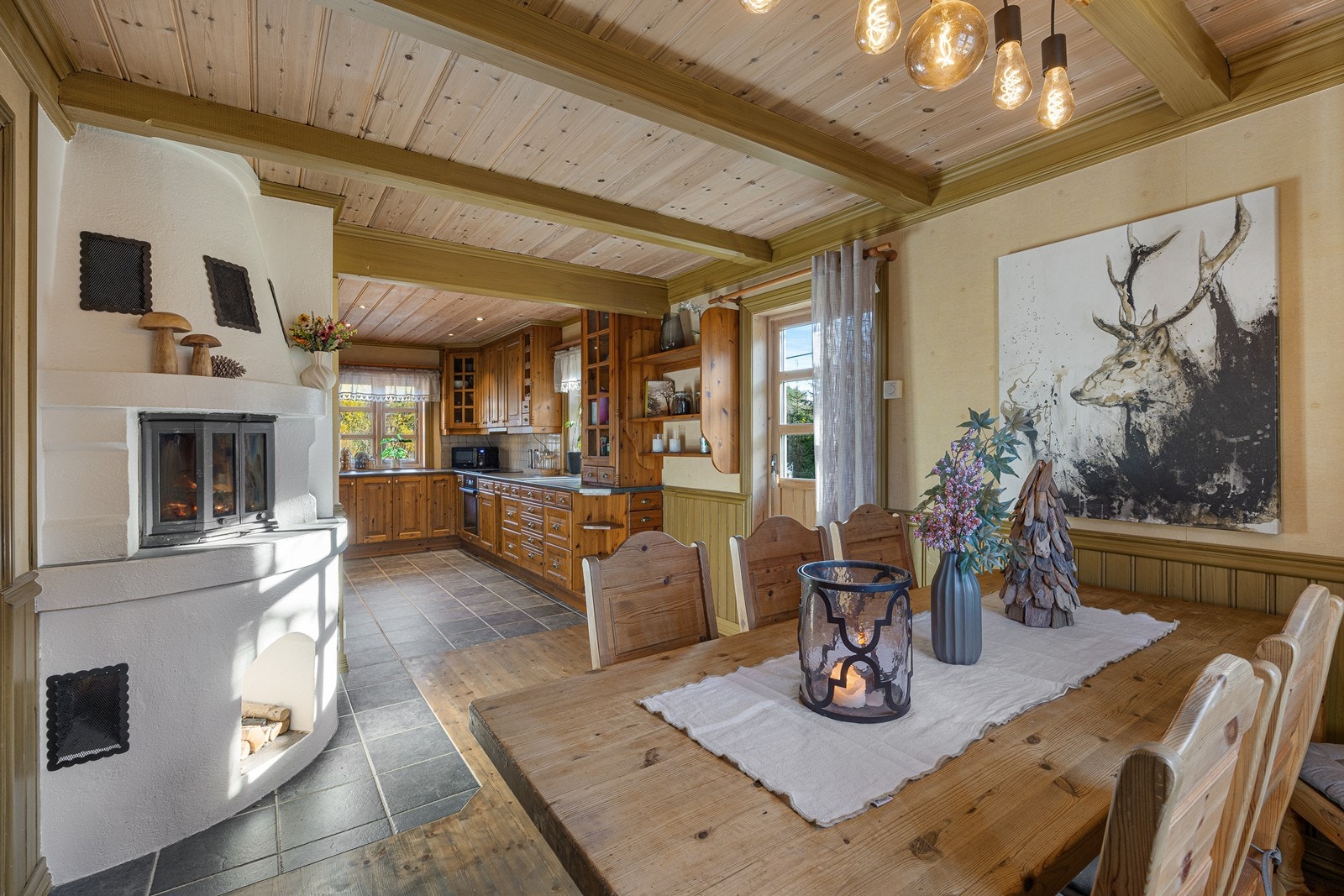 Spisestuen glir sømløst over i et flott kjøkken med egen spiseplass. Galleribilde