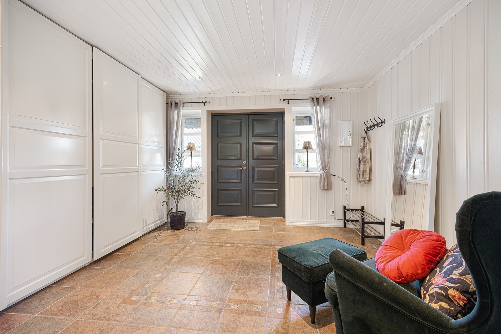 Entreen er utstyrt med gulvvarme, og yttertøyet ryddes enkelt bort i en stor skyvedørsgarderobe. Galleribilde