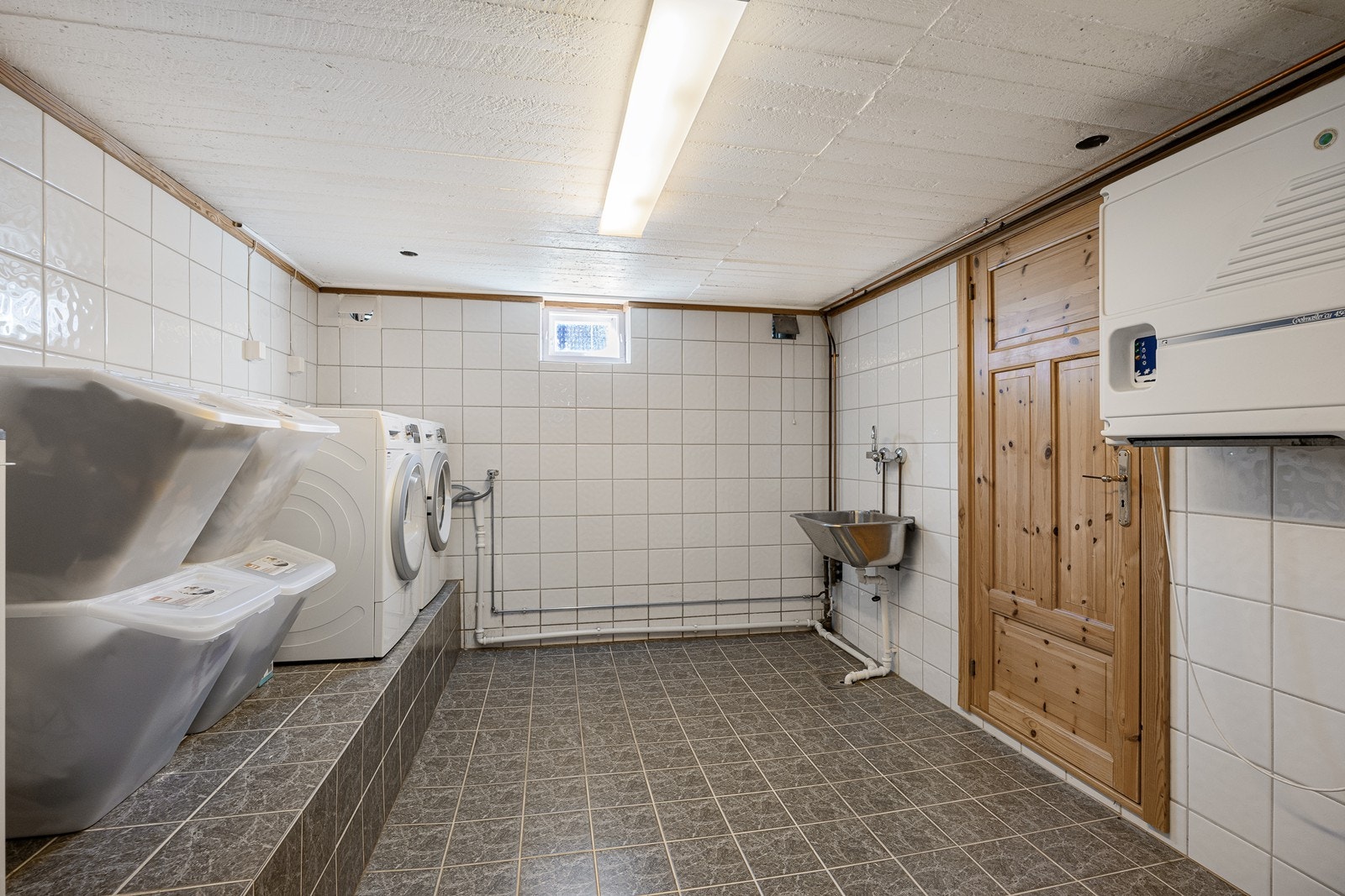 I underetasjen har boligen et eget vaskerom med fliser, gulvvarme og utslagsvask. Galleribilde