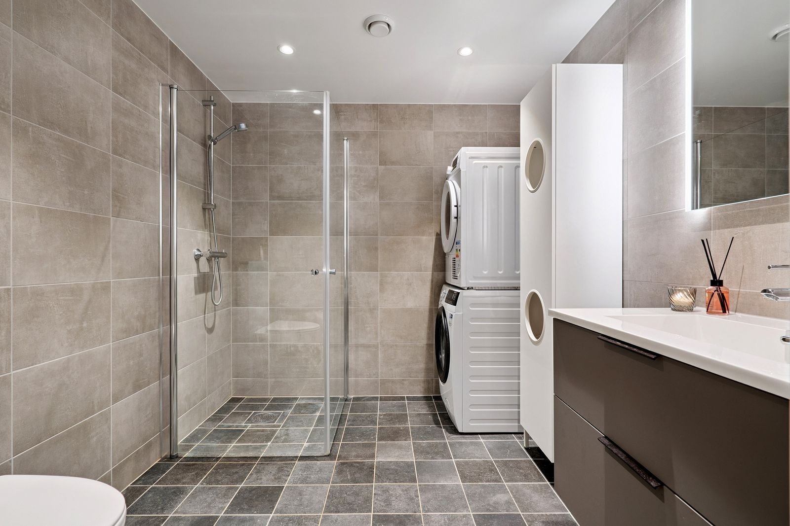 Flislagt og pent bad med innfellbare dusjdører, som gir maksimal benyttelse av plassen. Galleribilde