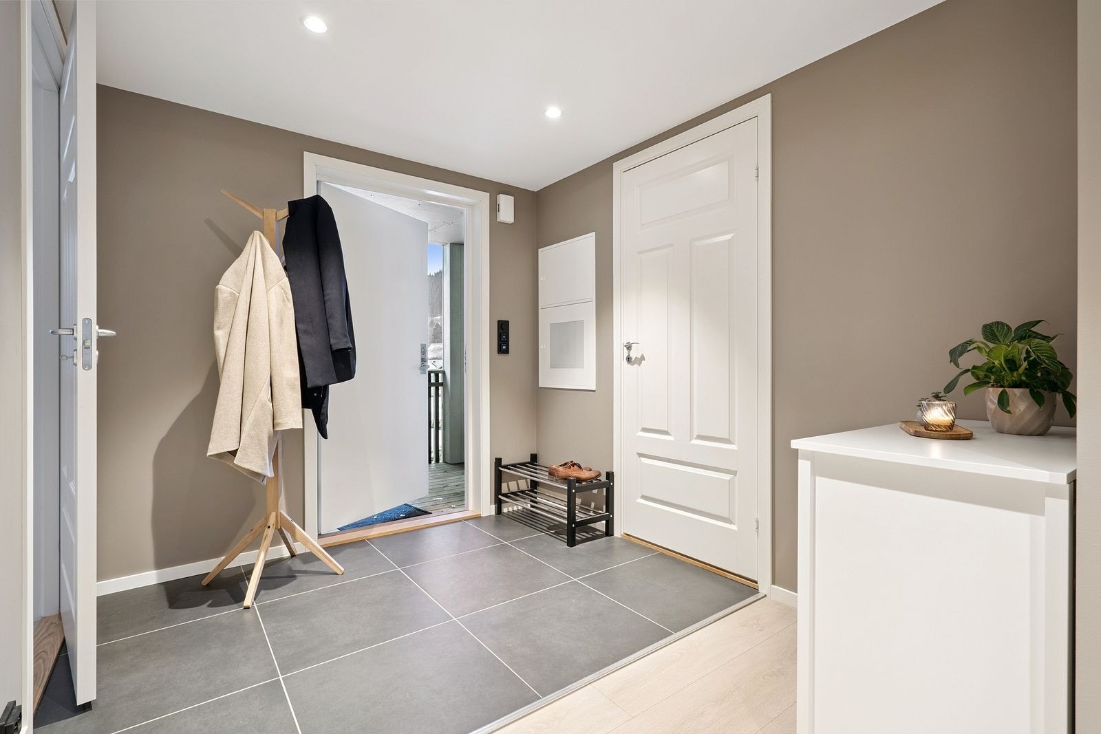 Romslig entré med delvis flislagt gulv og muligheter for å henge fra seg yttertøy o.l. Galleribilde