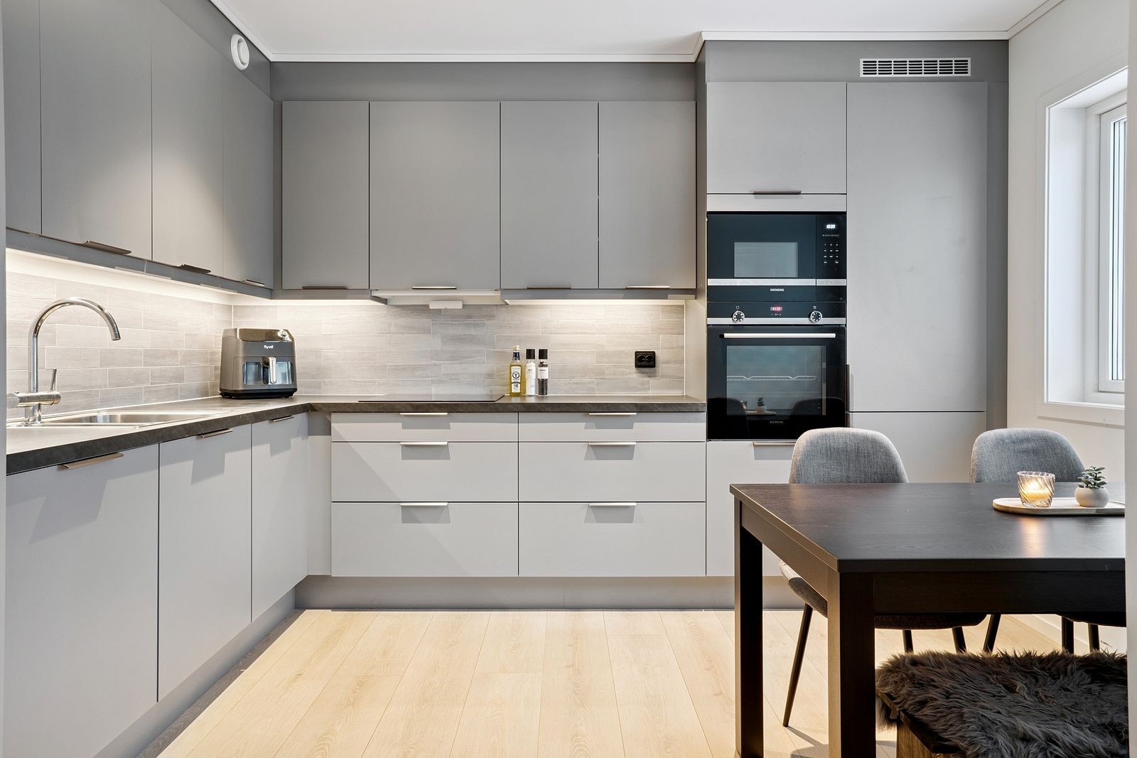 Pent og moderne kjøkken med mye skap- og benkeplass, samt integrerte hvitevarer. Galleribilde