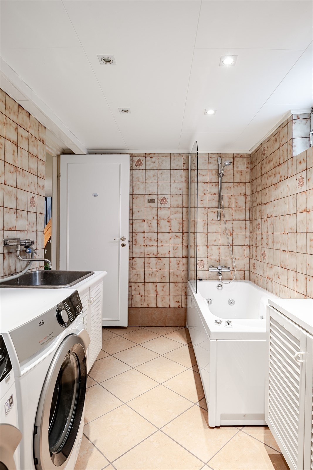 Baderommet er også utstyrt med badekar med glassvegg og dusj, innredning med utslagskum og opplegg for vaskemaskin. Galleribilde