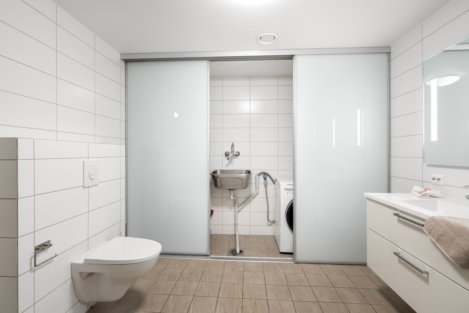 Flott, helfliset bad med praktisk vaskeromsinnredning. Galleribilde