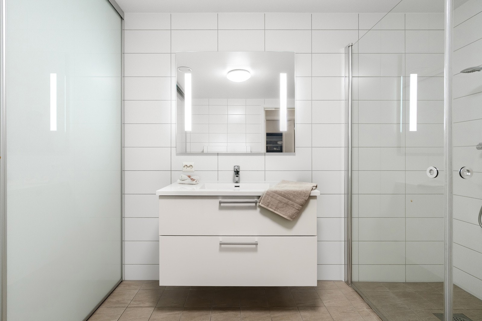 Fliser på både gulv og vegger gir et helhetlig uttrykk, samtidig som vannbåren fjernvarme i gulvet bidrar til ekstra komfort i hverdagen og mer energieffektiv oppvarming. Galleribilde