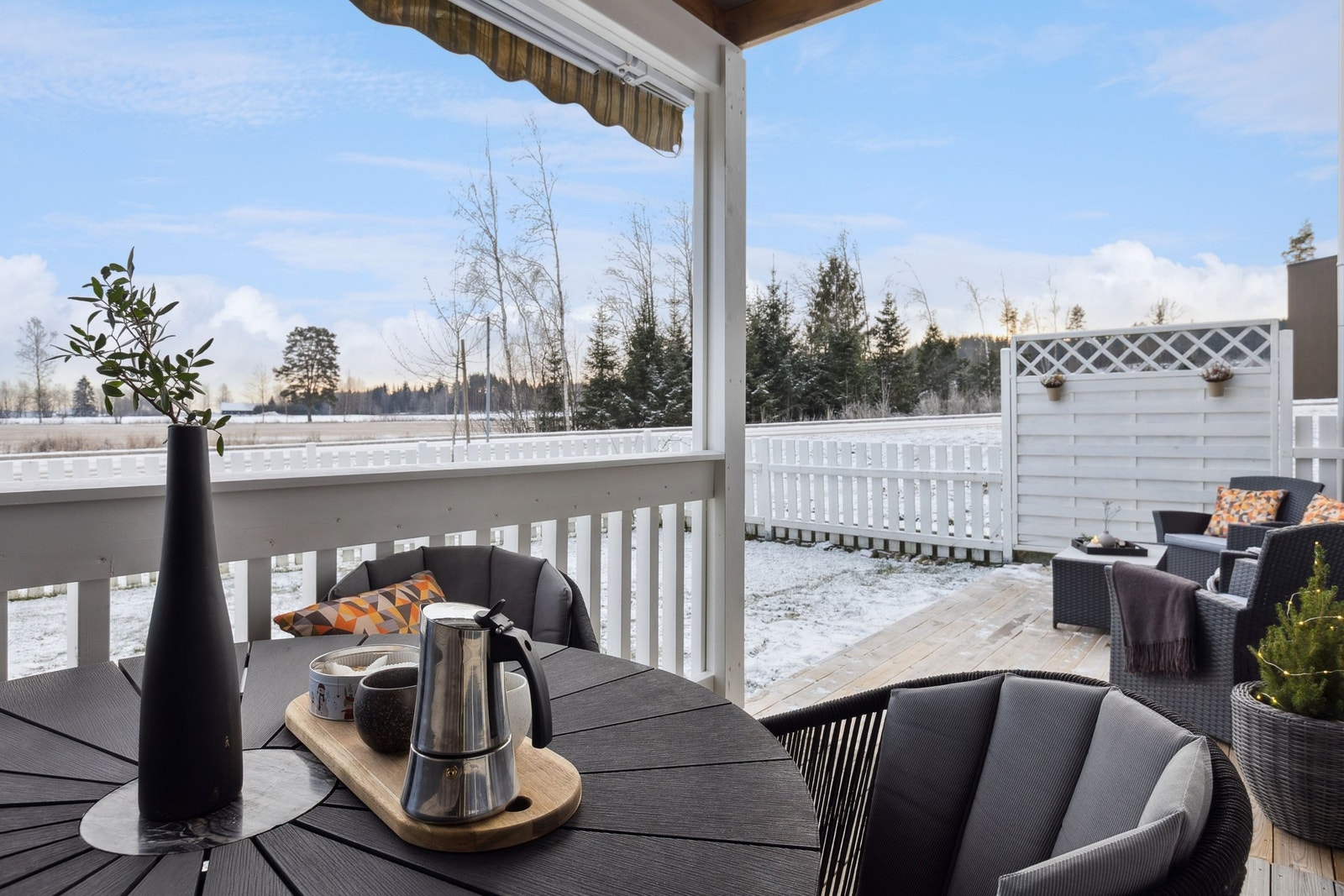 Stor og solrik terrasse med flott utsikt mot åpent landskap og skog Galleribilde