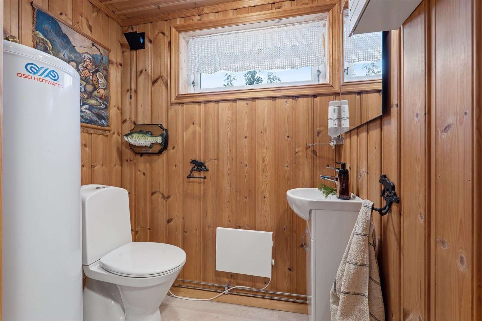 Toalettrommet har panel på vegger og tak, samt klikkvinyl på gulvet. Varmtvannsbereder og rør-i-rør-skap er plassert i rommet. Galleribilde