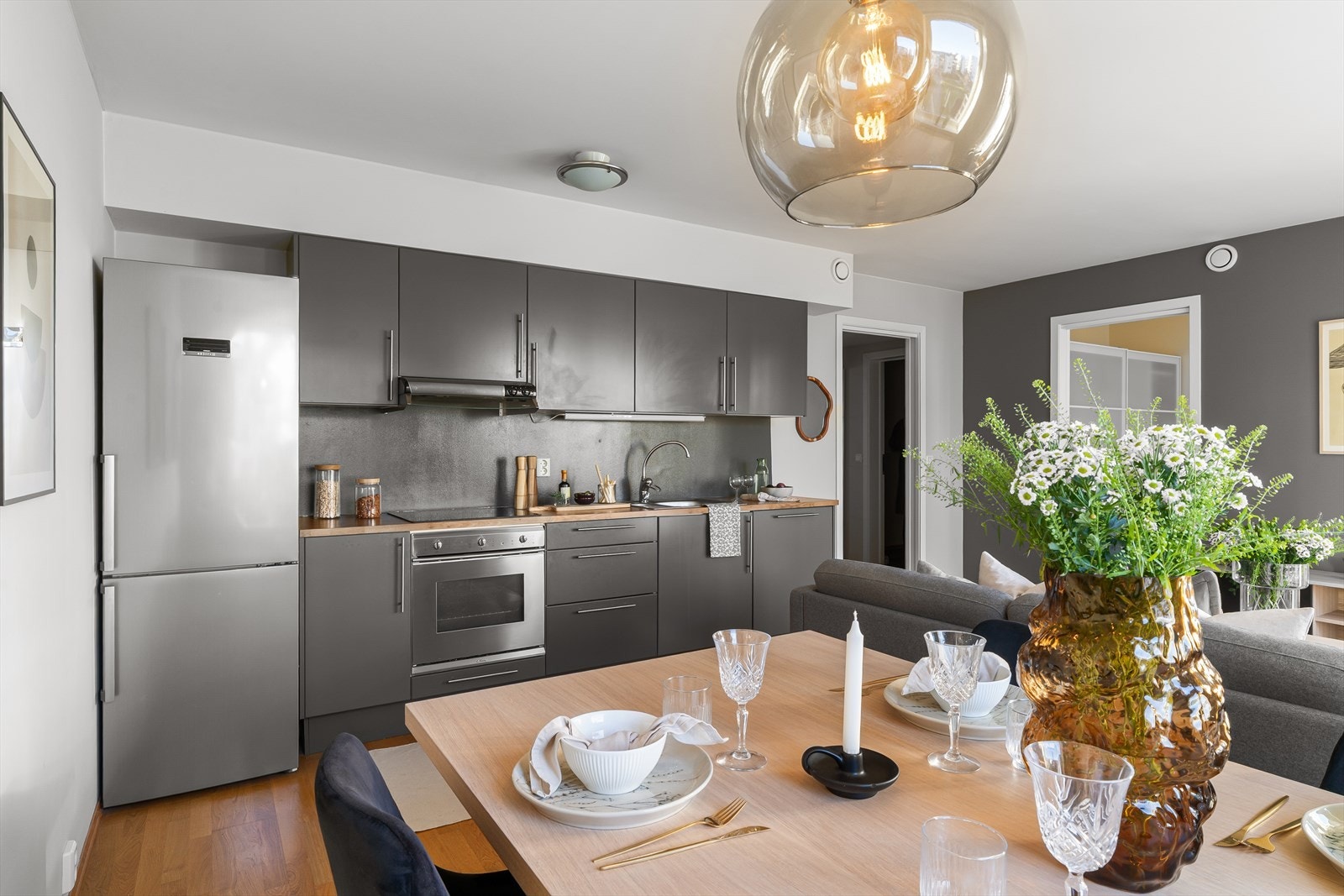 Flott kjøkken med innredning i mørkegrå utførelse og pen benkeplate Galleribilde