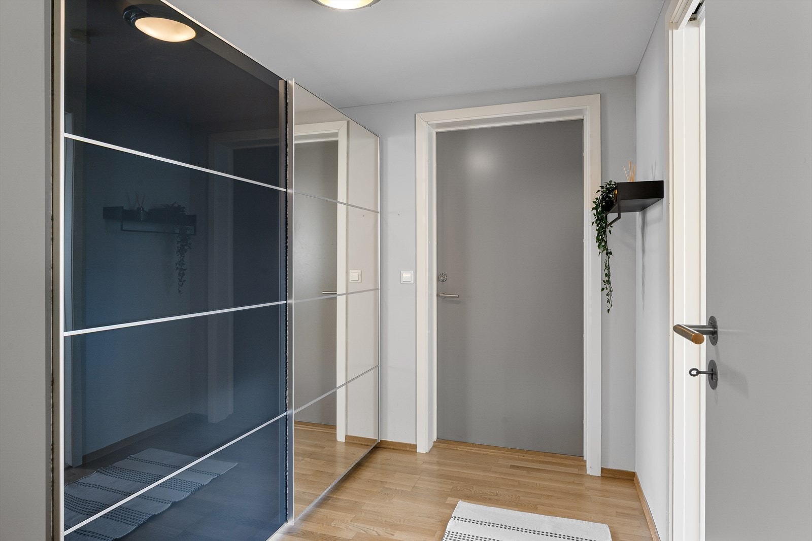 Romslig inngangsparti med stor skyvedørsgarderobe Galleribilde