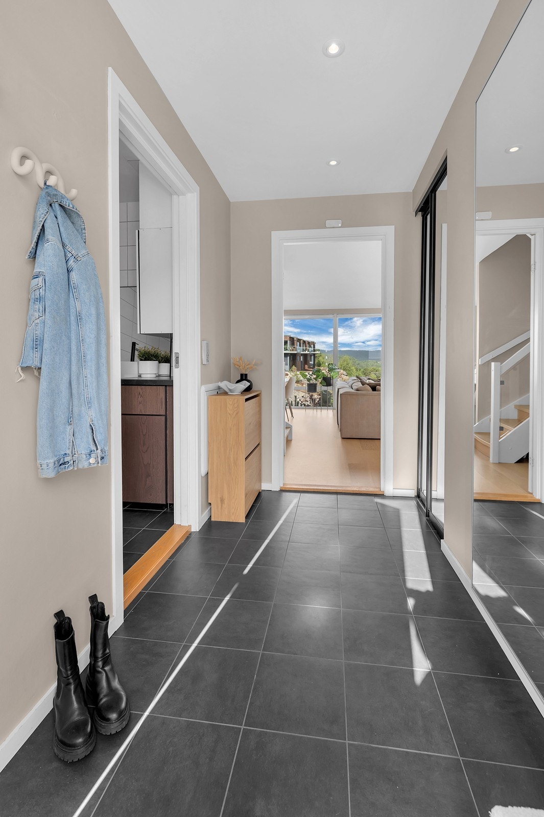 Velkommen inn til en flislagt gang. Skyvedørsgarderobe med plass til yttertøy og sko. Galleribilde