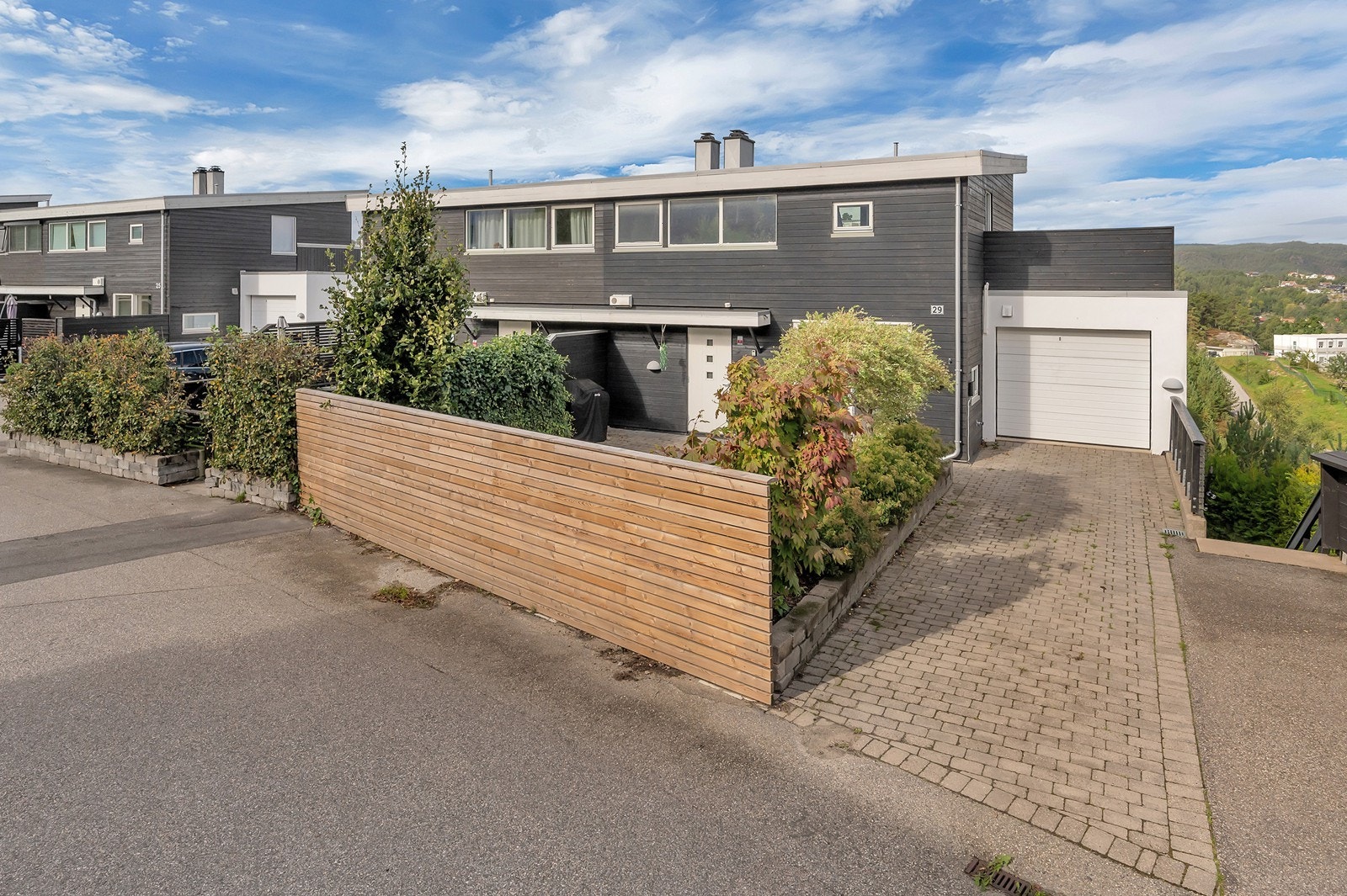 Tomten er flott innkranset med gjerde og bed med busker og vekster. Tomten er felles mellom seksjon 1 og 2. Galleribilde