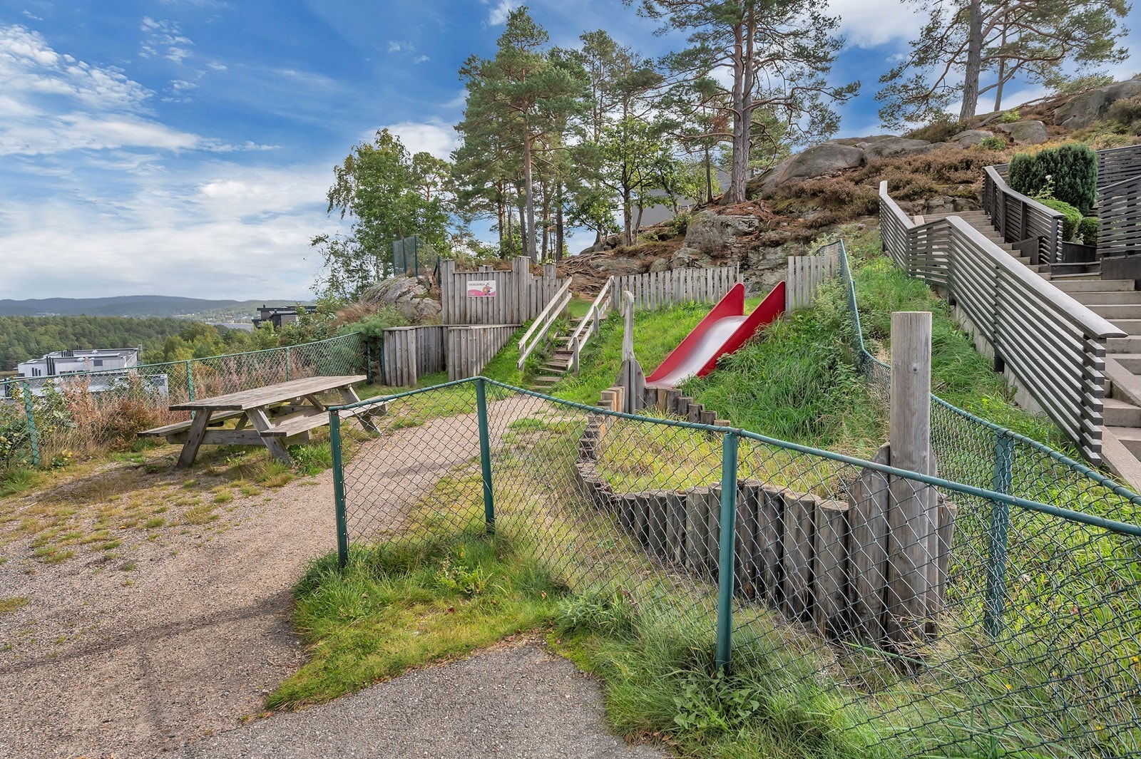 Lekeplass rett utenfor døra med friområde i bakgrunnen. Galleribilde