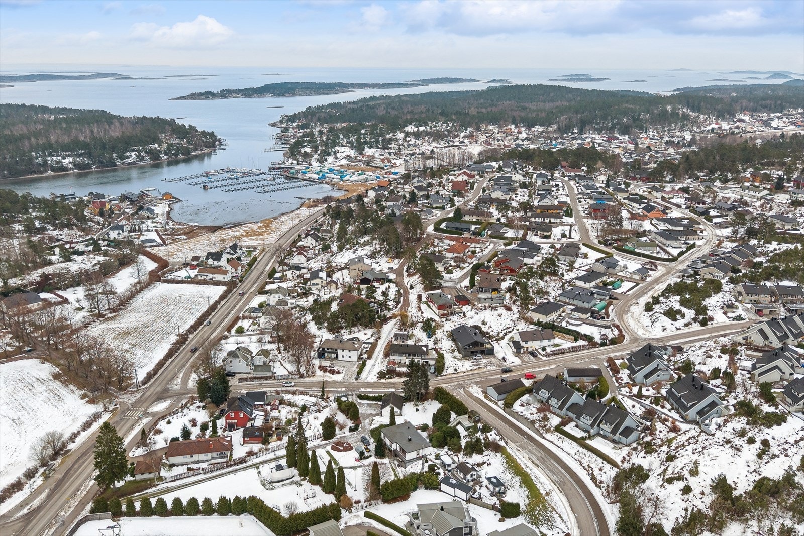 Dronefoto av bolig og nærområdet. Her bor du i et veletablert og familievennlig område med kort gangavstand til barnehager, skoler og dagligvarebutikk, en perfekt kombinasjon av trygghet og bekvemmelighet. Galleribilde