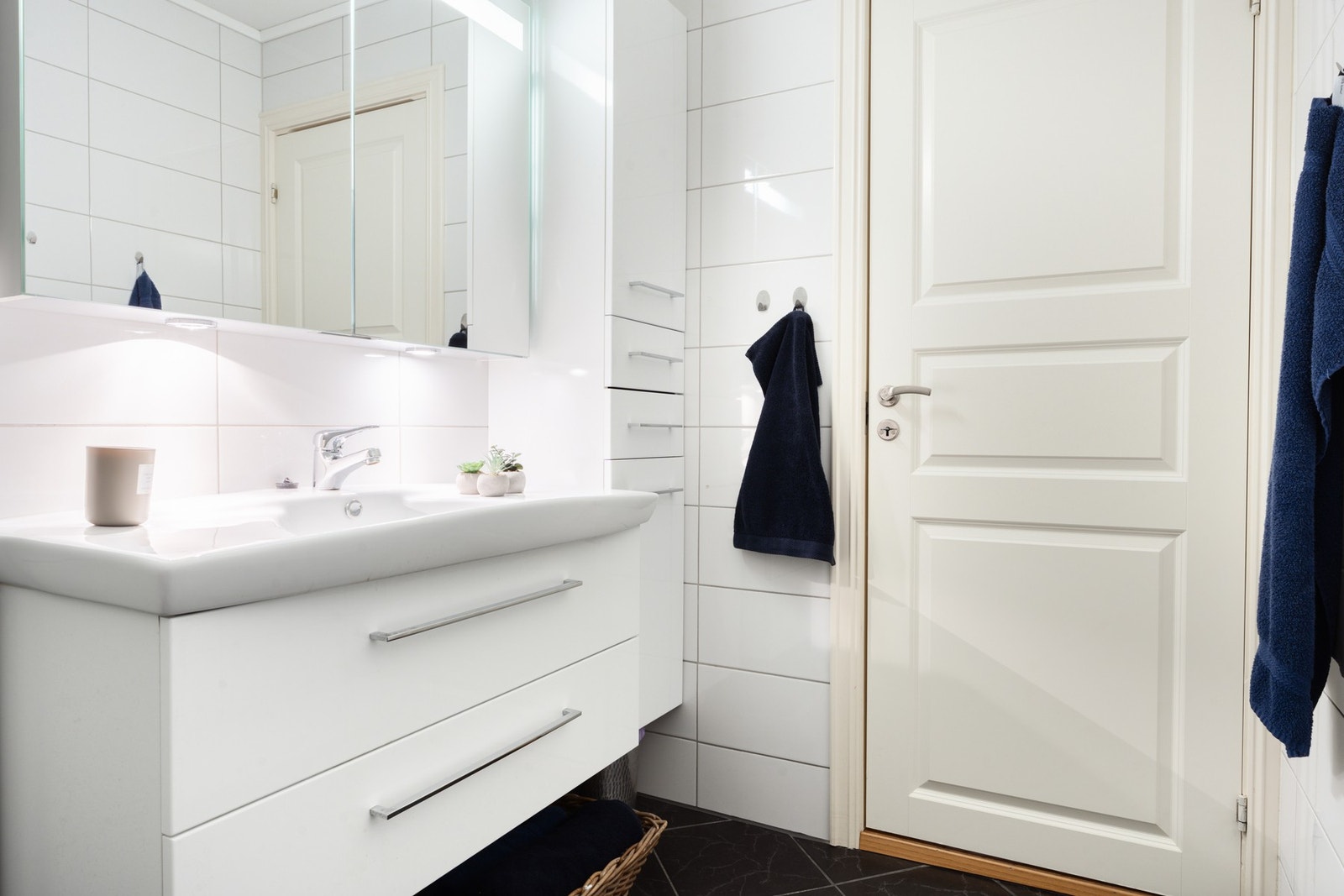 Badet er innredet med heldekkende servant, speilskap og dusj med glassdør. Galleribilde