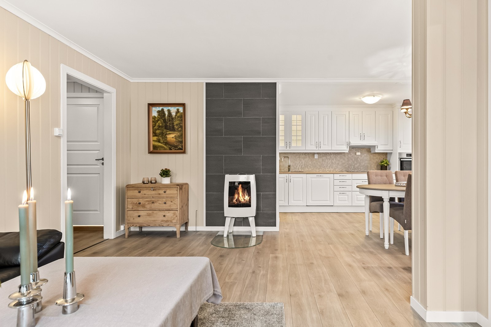 En moderne vedovn er sentralt plassert og gir effektiv varme til oppholdsrommet. Galleribilde