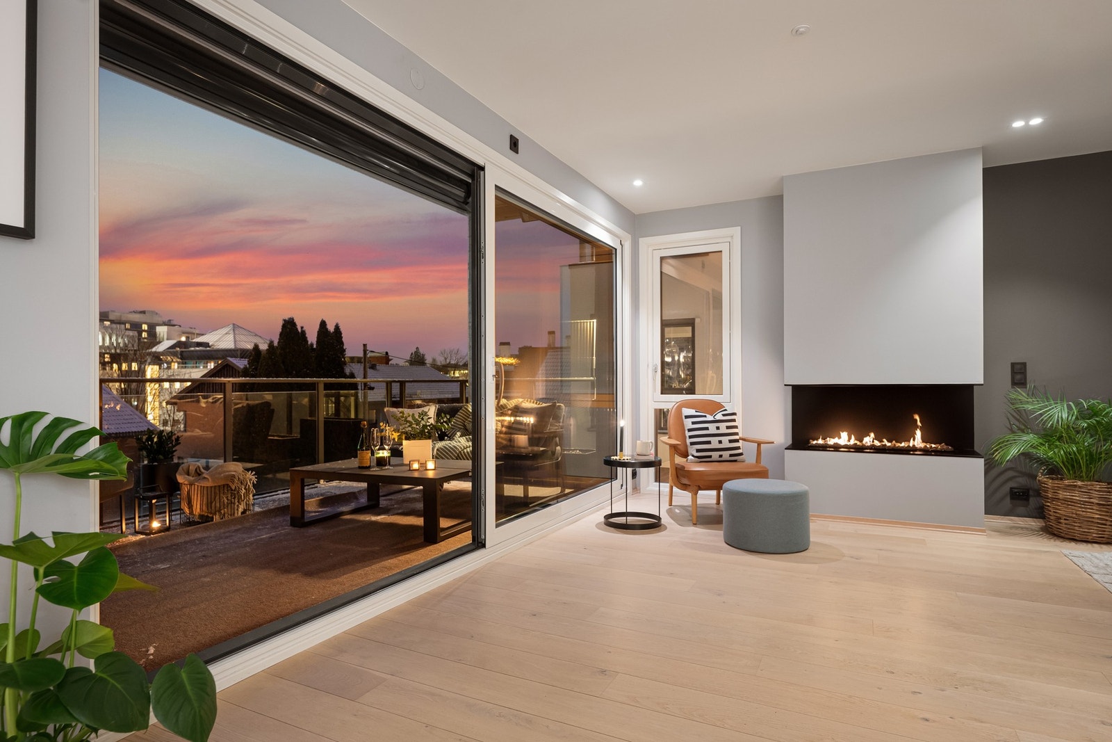 Stor skyvedør gir en glidende overgang mellom stue og uteplass Galleribilde