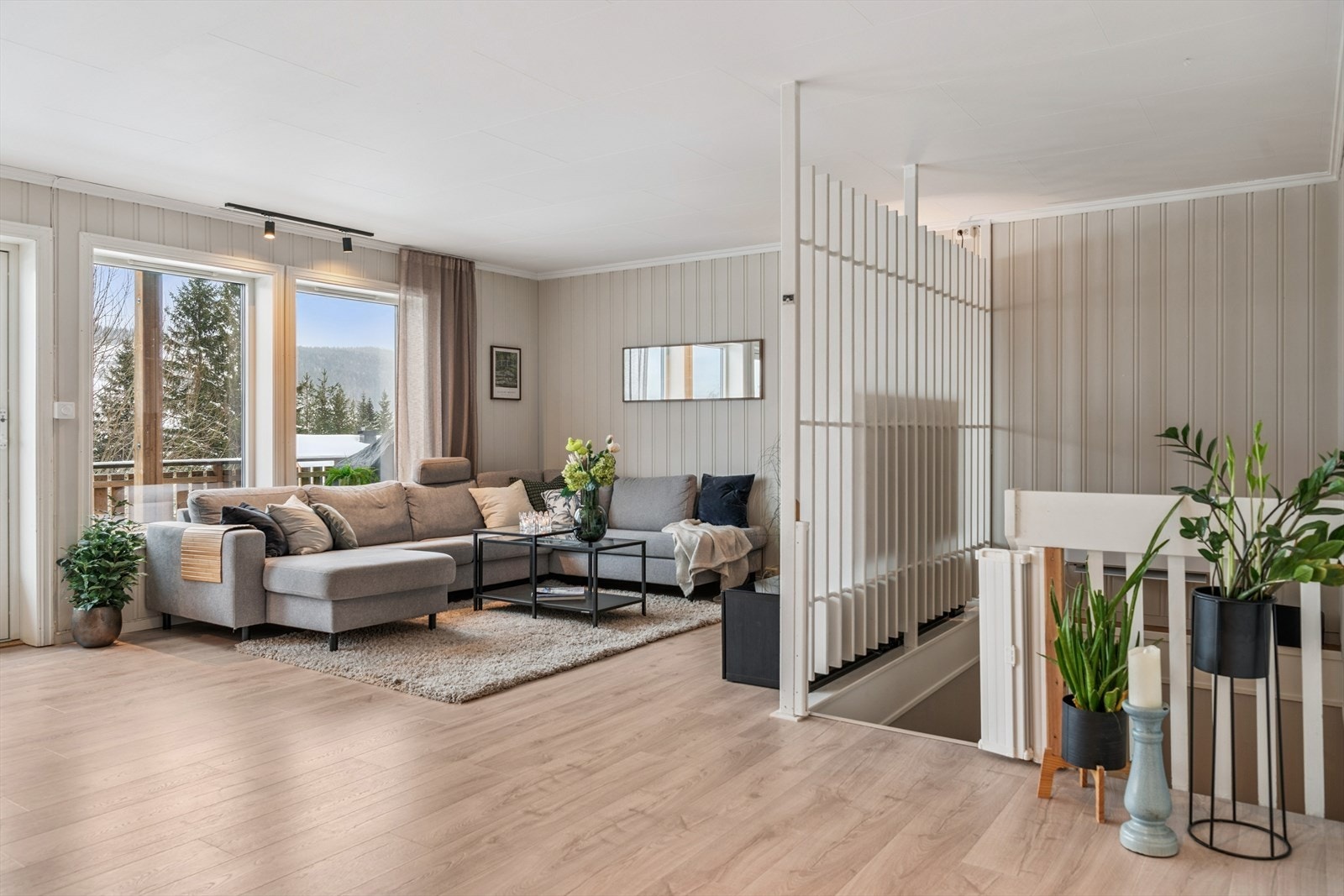 Stuen er et sosialt og åpent rom med god plass til både spisebord og en romslig sofagruppe. Galleribilde