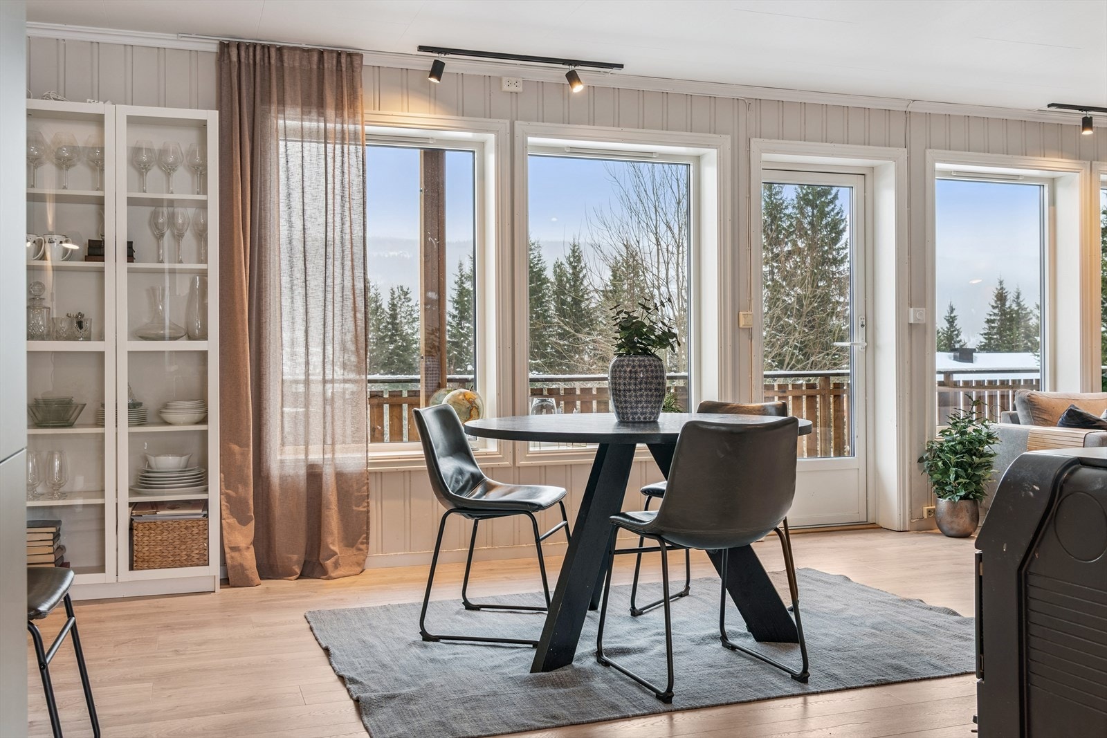 Store vindusflater i stuen gir rikelig med naturlig lys og rammer inn utsikten mot landskapet. Galleribilde