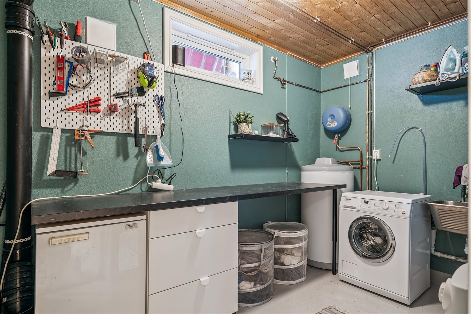 Stort og praktisk vaskerom / teknisk rom med opplegg for vaskemaskin og en god arbeidsbenk. Oppvarming med panelovn. Galleribilde