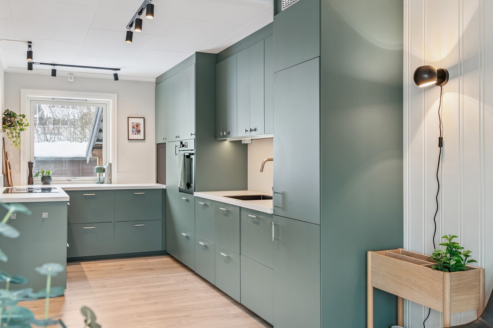 Stilrent og moderne kjøkken med slette, grønne fronter og rikelig med skap- og benkeplass. Galleribilde