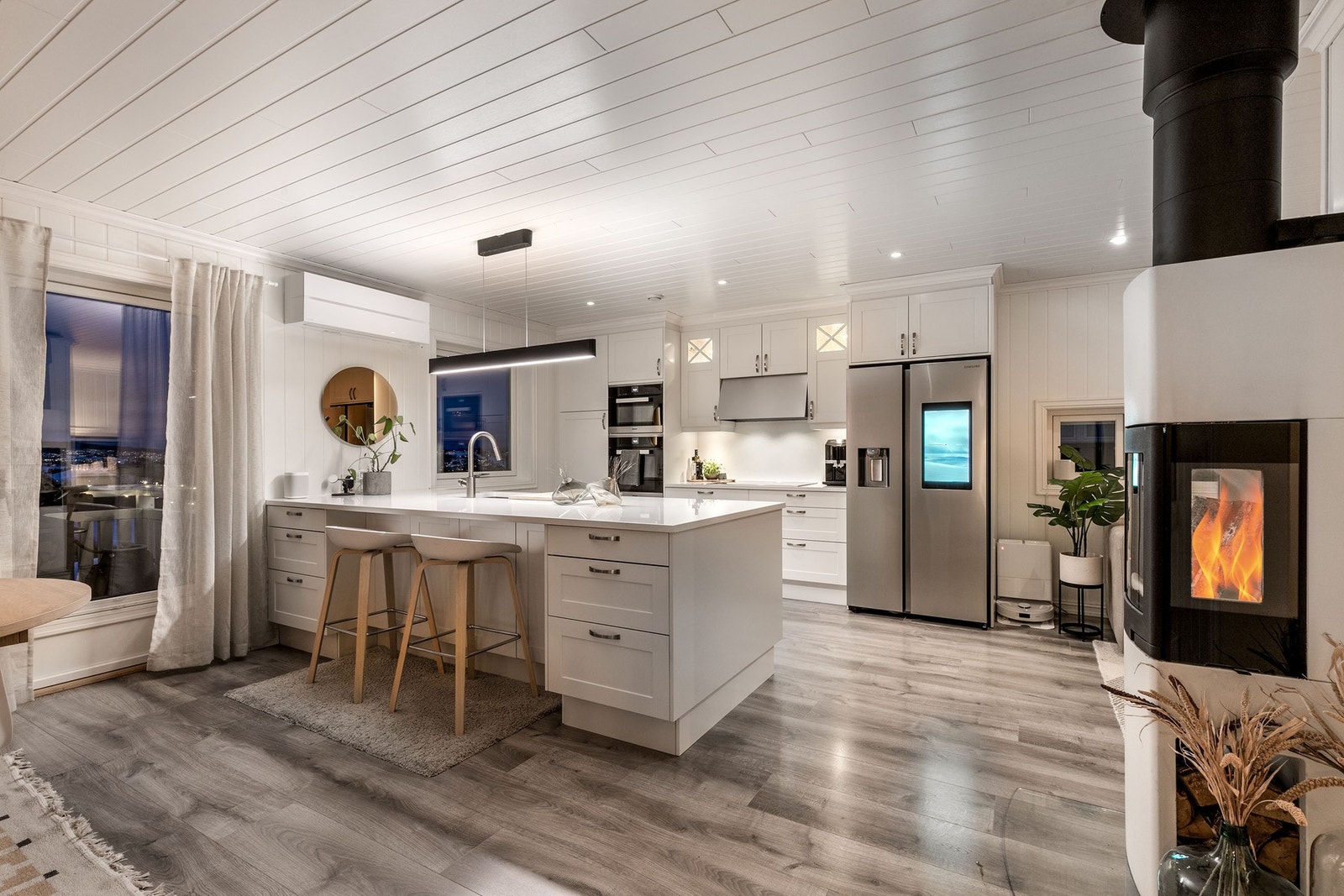 Den åpne stuen har lysmalte overflater og fremstår som luftig Galleribilde