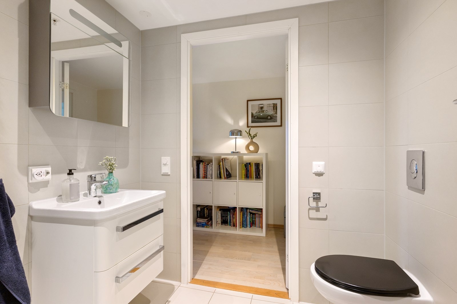 Badet er utstyrt med dusjsone med innfellbare dusjdører, veggmontert wc samt servantskap med ettgreps blandebatteri fra Oras. Galleribilde