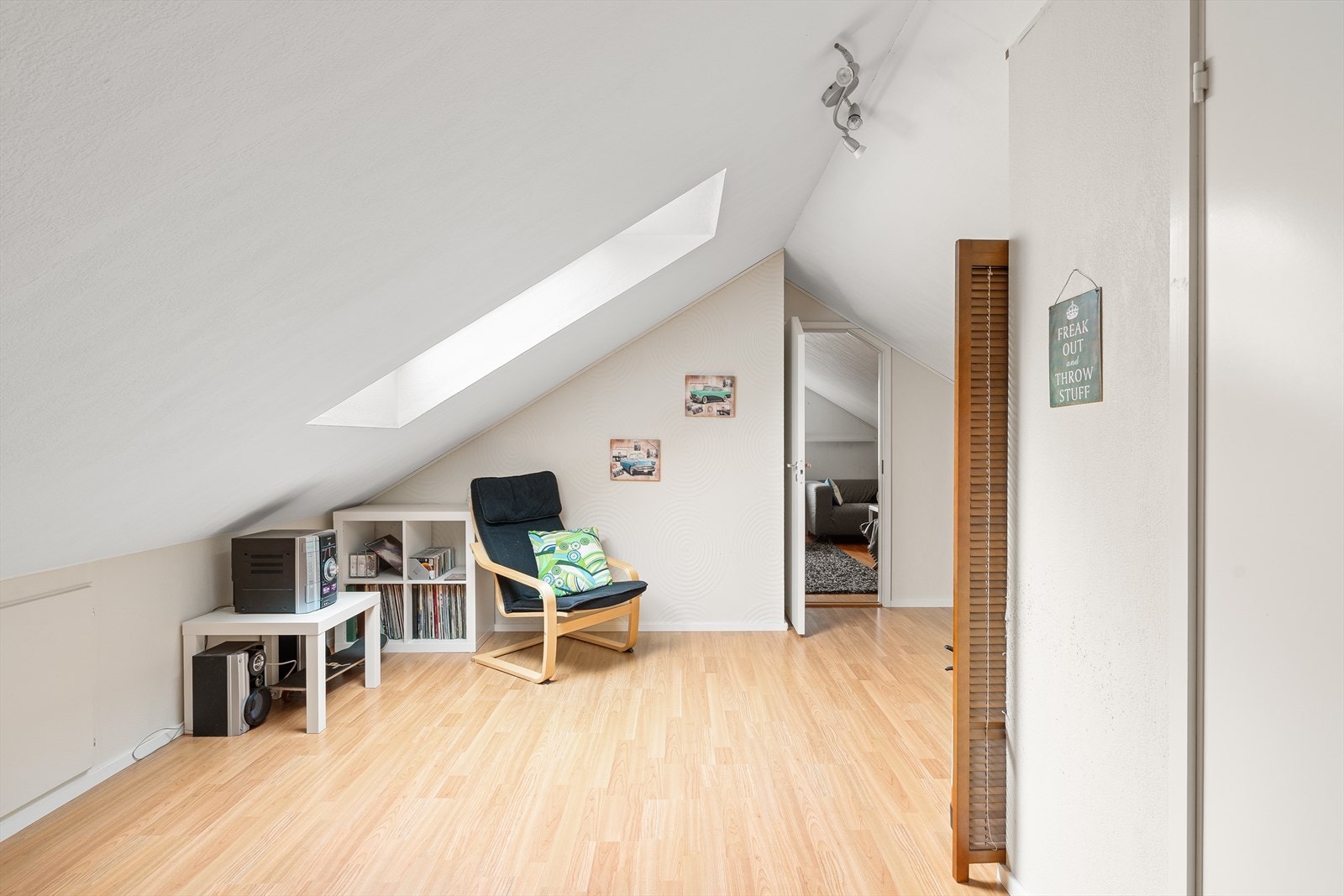 Lyst og innbydende loftsrom med skråtak og naturlig lys, perfekt som avslapningsområde eller kreativ sone. Galleribilde