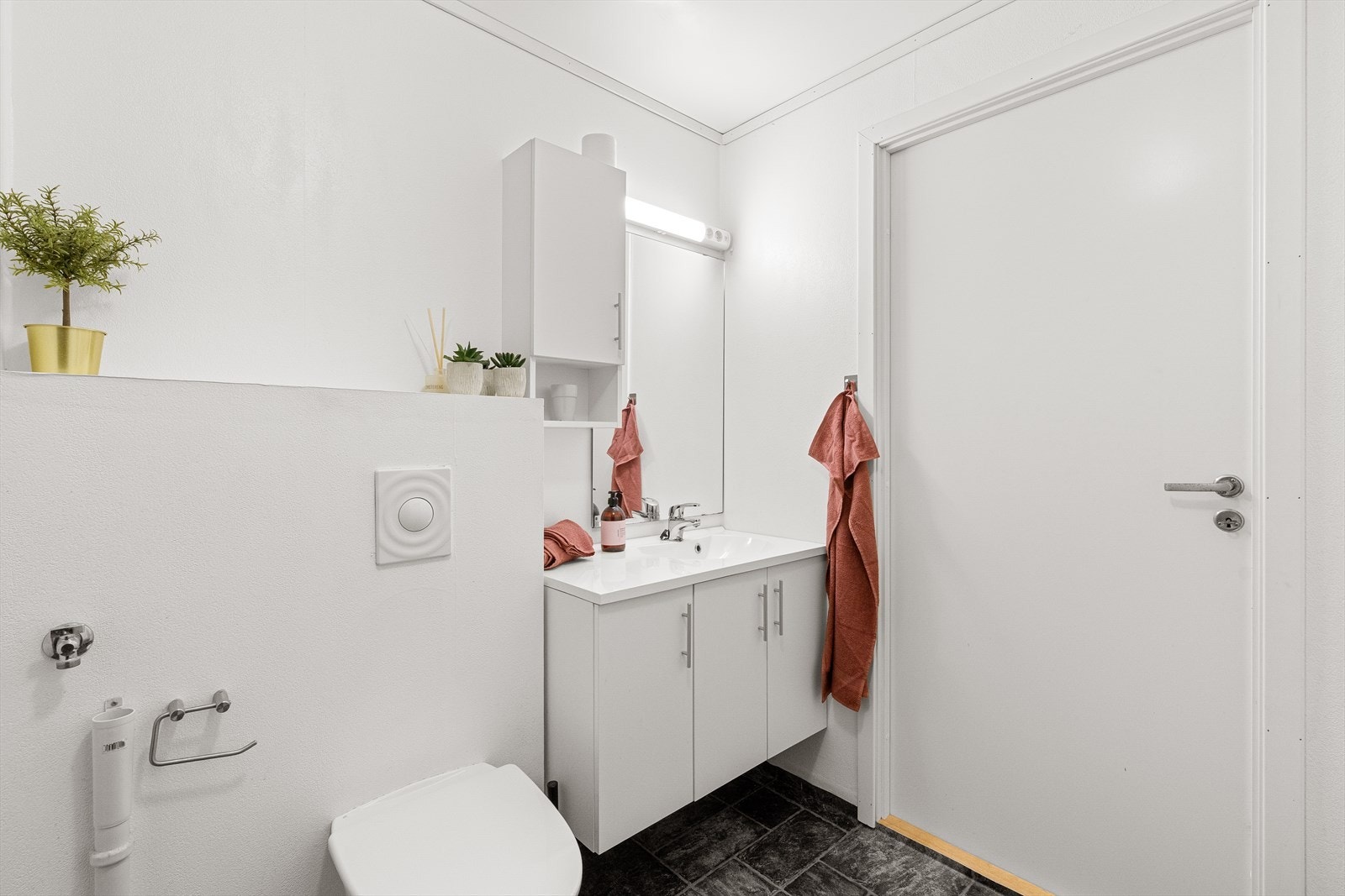 Badet er utstyrt med dusjhjørne, vegghengttoalett og servant samt opplegg for vaskemaskin og tørketrommel. Galleribilde