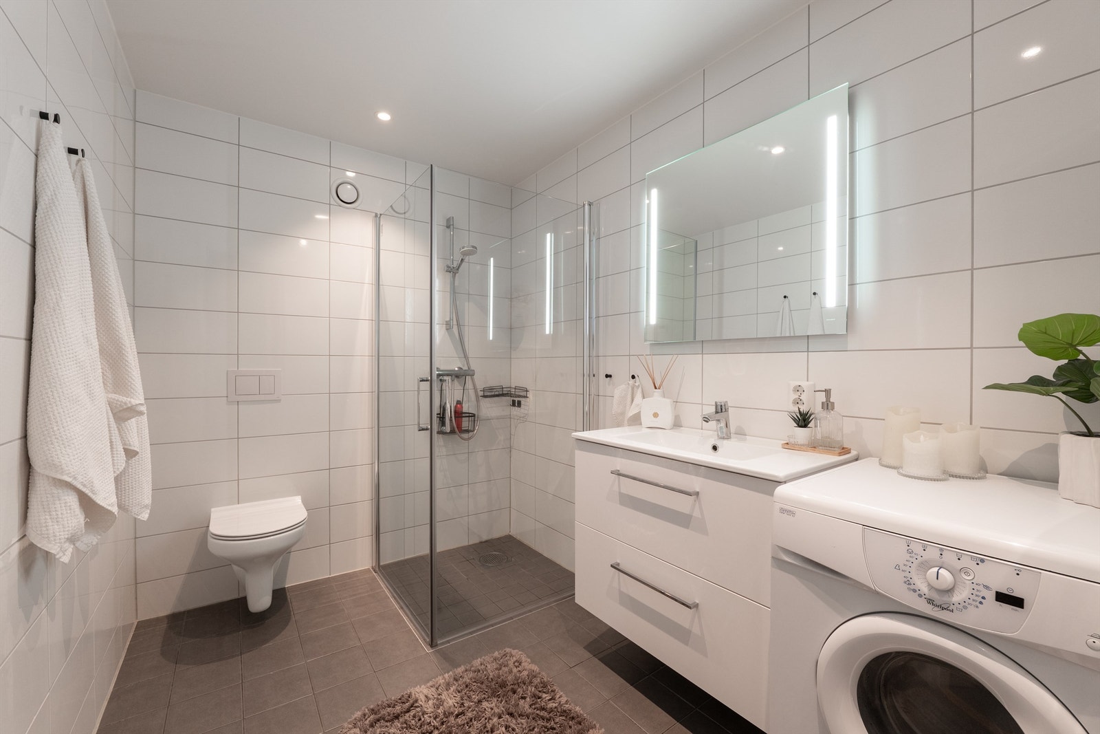 Badet har et lyst og nøytralt uttrykk med hvit innredning og hvite veggfliser. Galleribilde