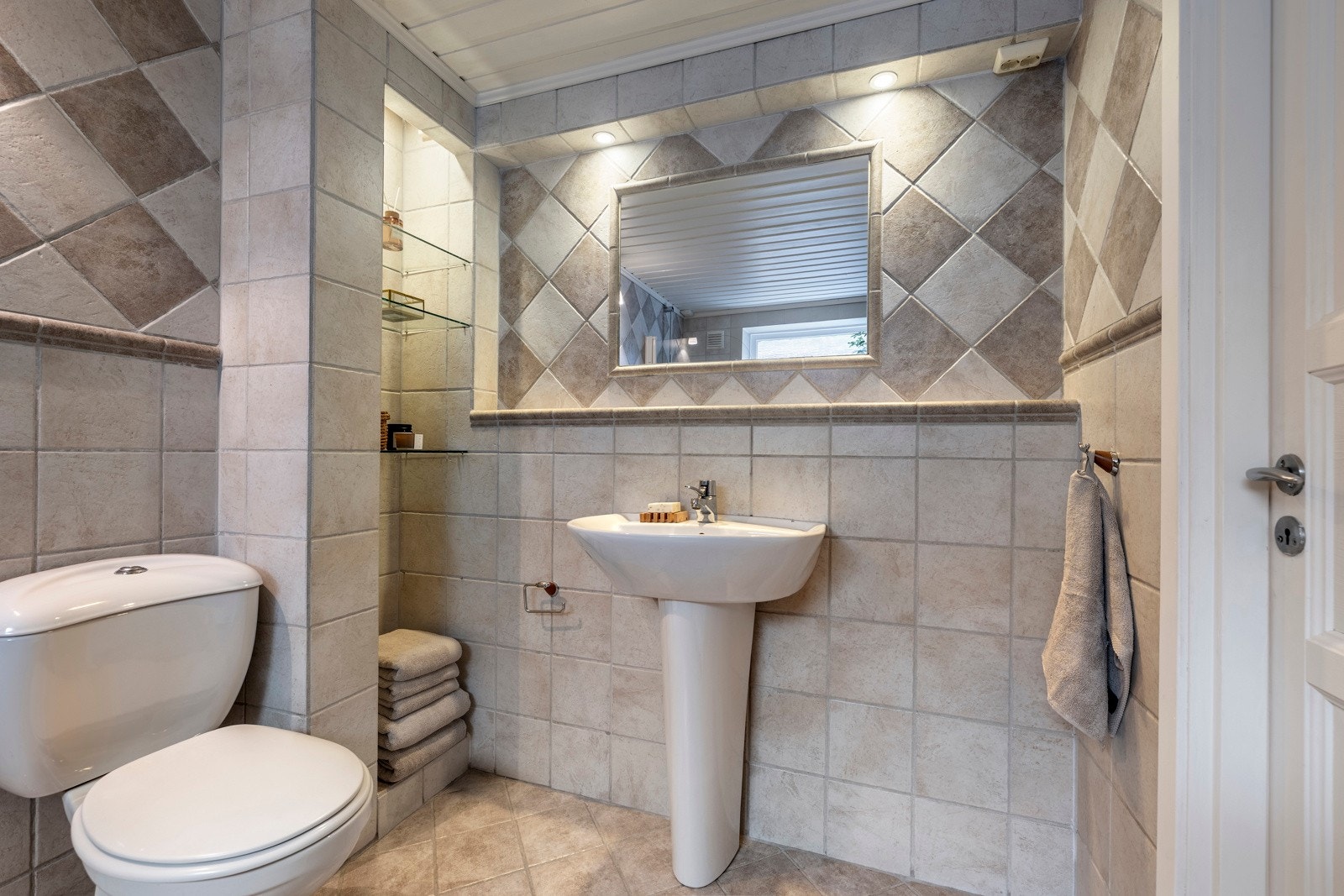 Badet har fliser på både vegger og gulv, samt varmekabler. Galleribilde