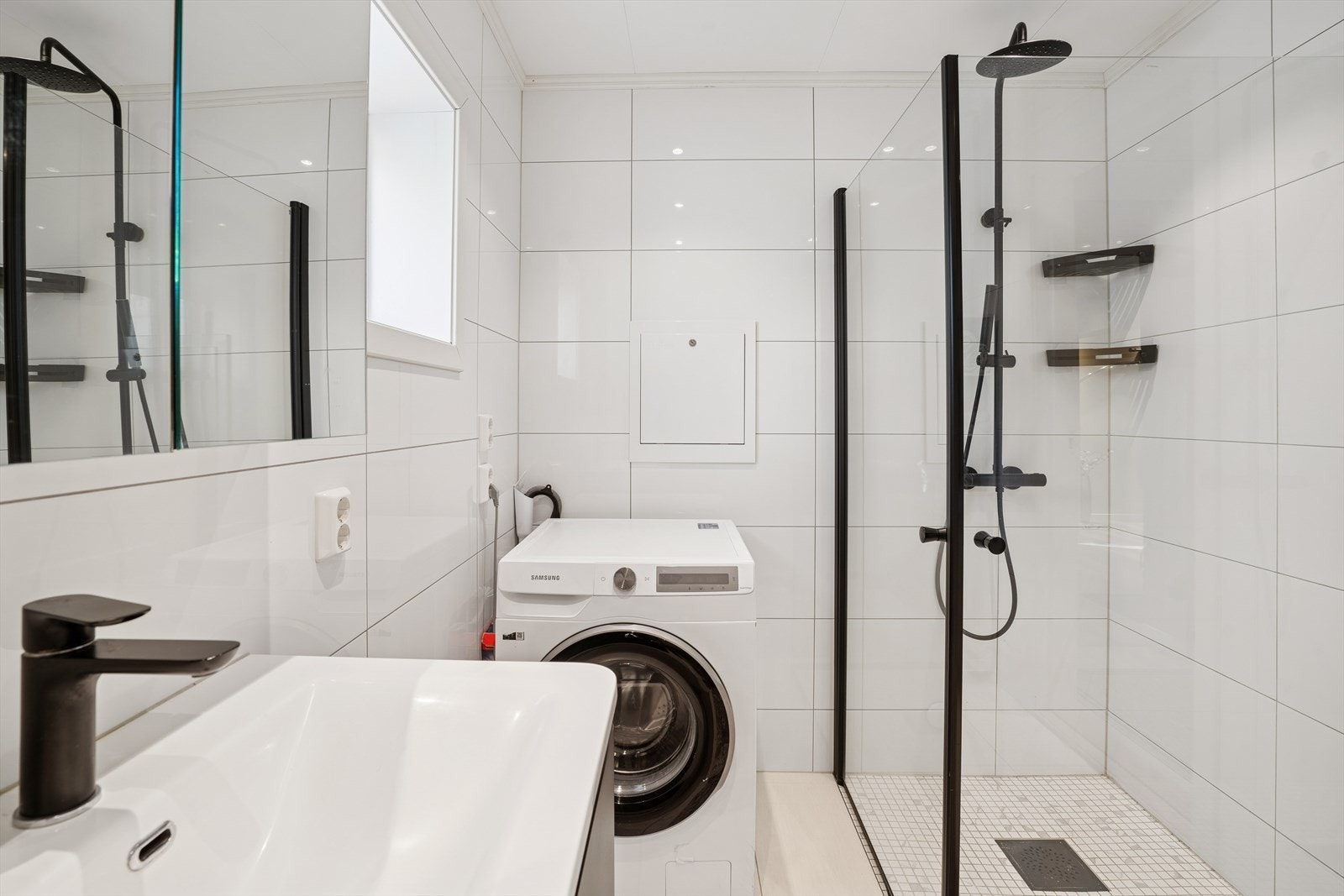 Badet er utstyrt med vegghengt toalett, dusjhjørne med glassvegger, innredning med nedfelt servant, speilskap, samt opplegg for vaskemaskin. Galleribilde