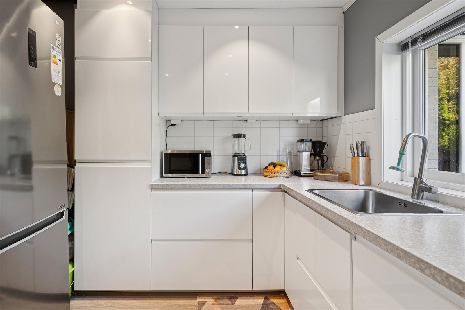 IKEA innredning fra 2023 med glatte fronter og laminert benkeplate med nedfelt oppvaskkum i rustfritt stål. Galleribilde