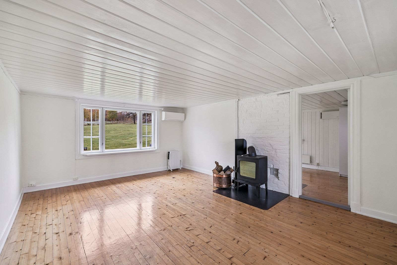 Stor og romslig stue med peisovn Galleribilde