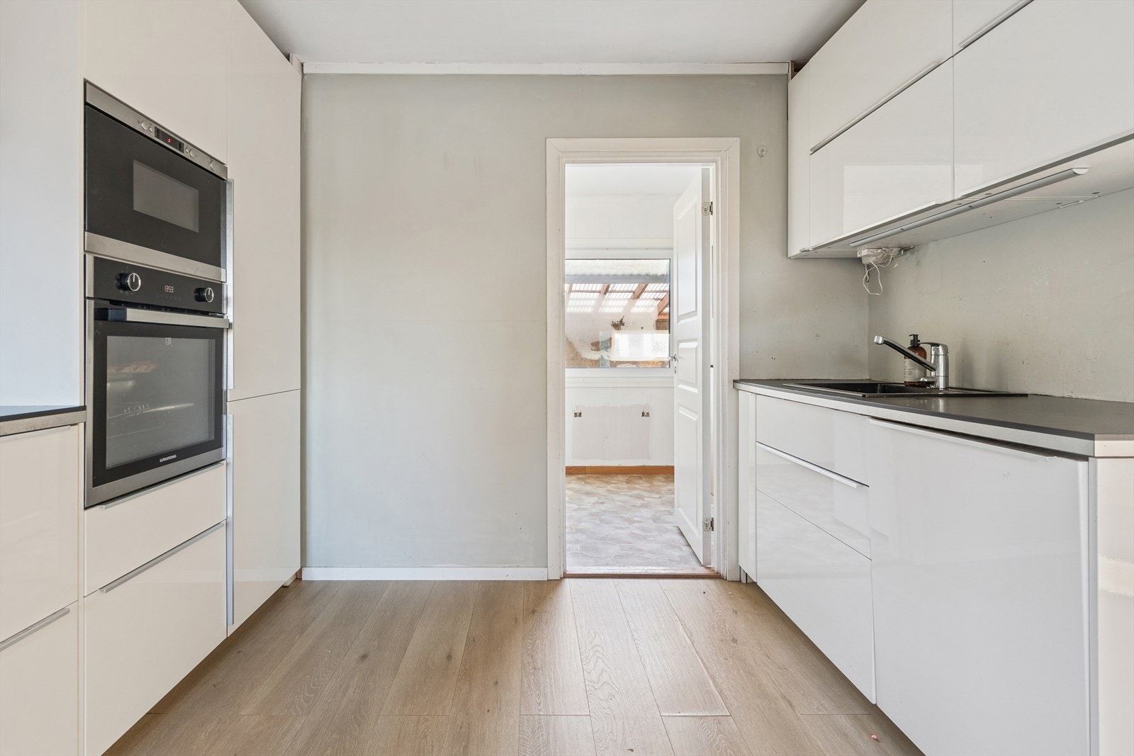 Kjøkkeninnredningen har takhøye overskap og integrerte hvitevarer. Galleribilde