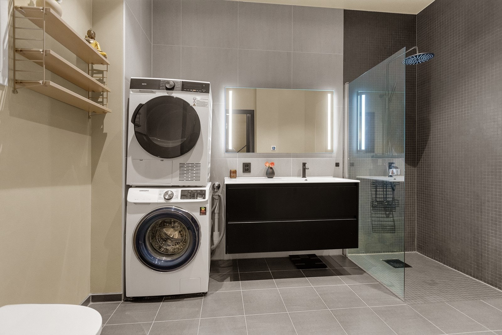 Badet er innredet med veggmontert WC, dusjplass, servant med ettgreps blandebatteri i innredning samt opplegg for vaskemaskin. Galleribilde