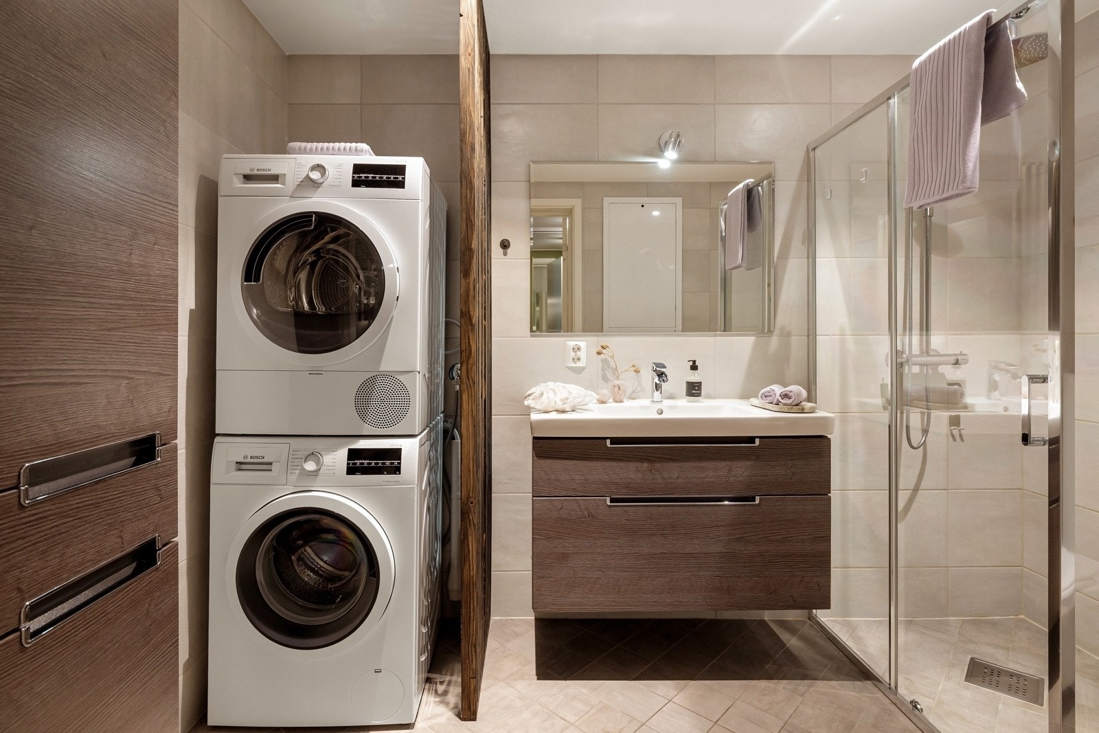 Det er utstyrt med gulvvarme og downlights i tak, og inneholder veggmontert toalett, dusj med glassdører samt baderomsinnredning med heldekkende servant, speil og belysning. Galleribilde