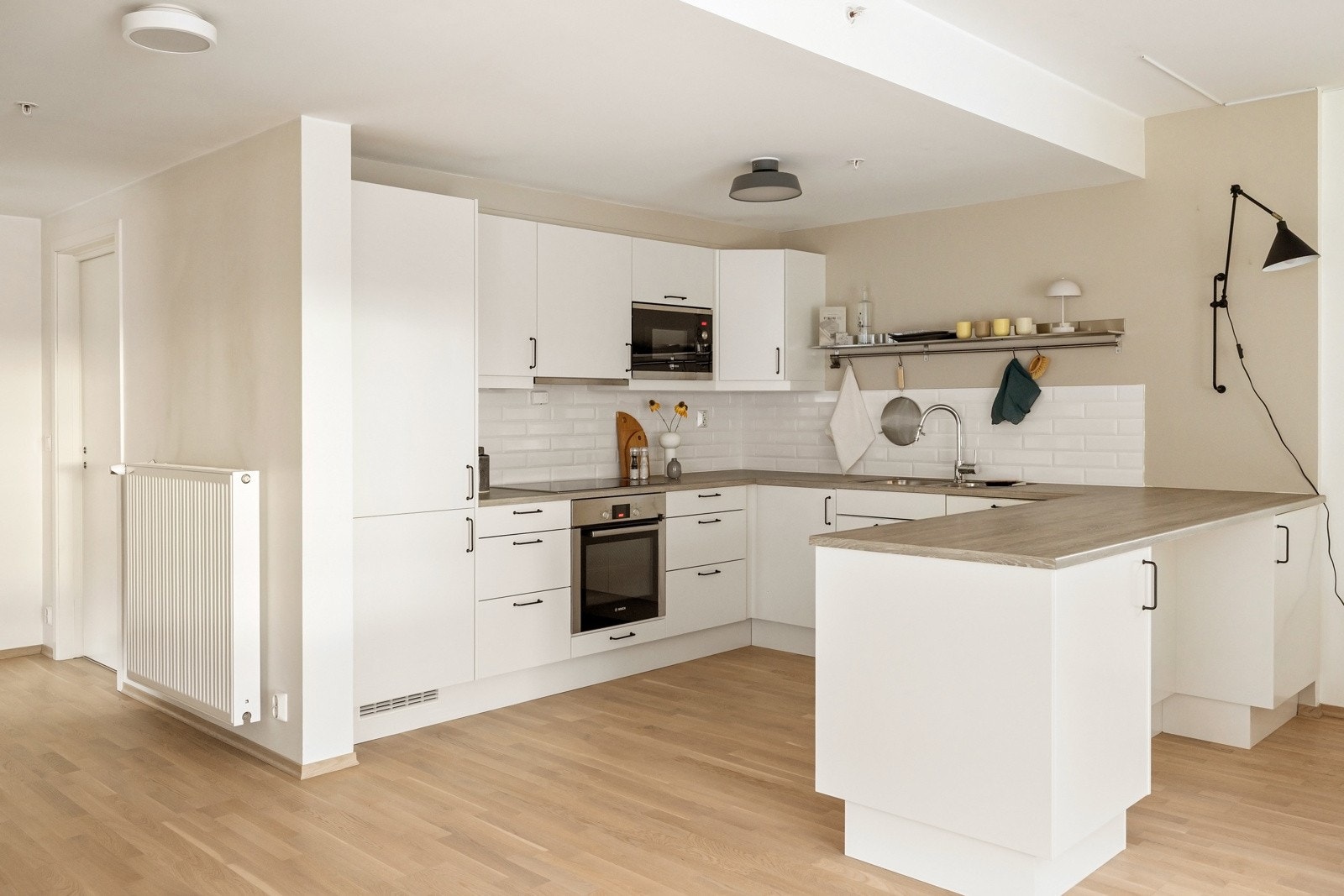 Det stilrene kjøkkenet er levert av Sigdal og har godt med skap- og benkeplass i en hesteskoløsning som gir kokken gode arbeidsvilkår Galleribilde