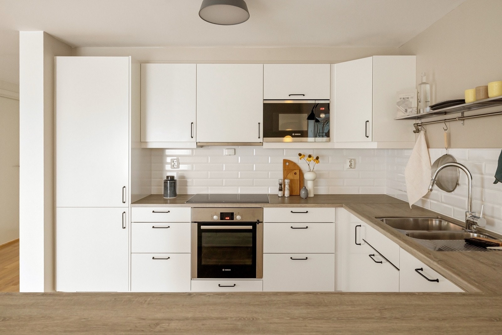 Her er det integrerte hvitevarer bestående av platetopp, stekeovn, ventilator, oppvaskmaskin, mikrobølgeovn samt kjøleskap med frysedel - alt sømløst integrert for et ryddig uttrykk. Galleribilde