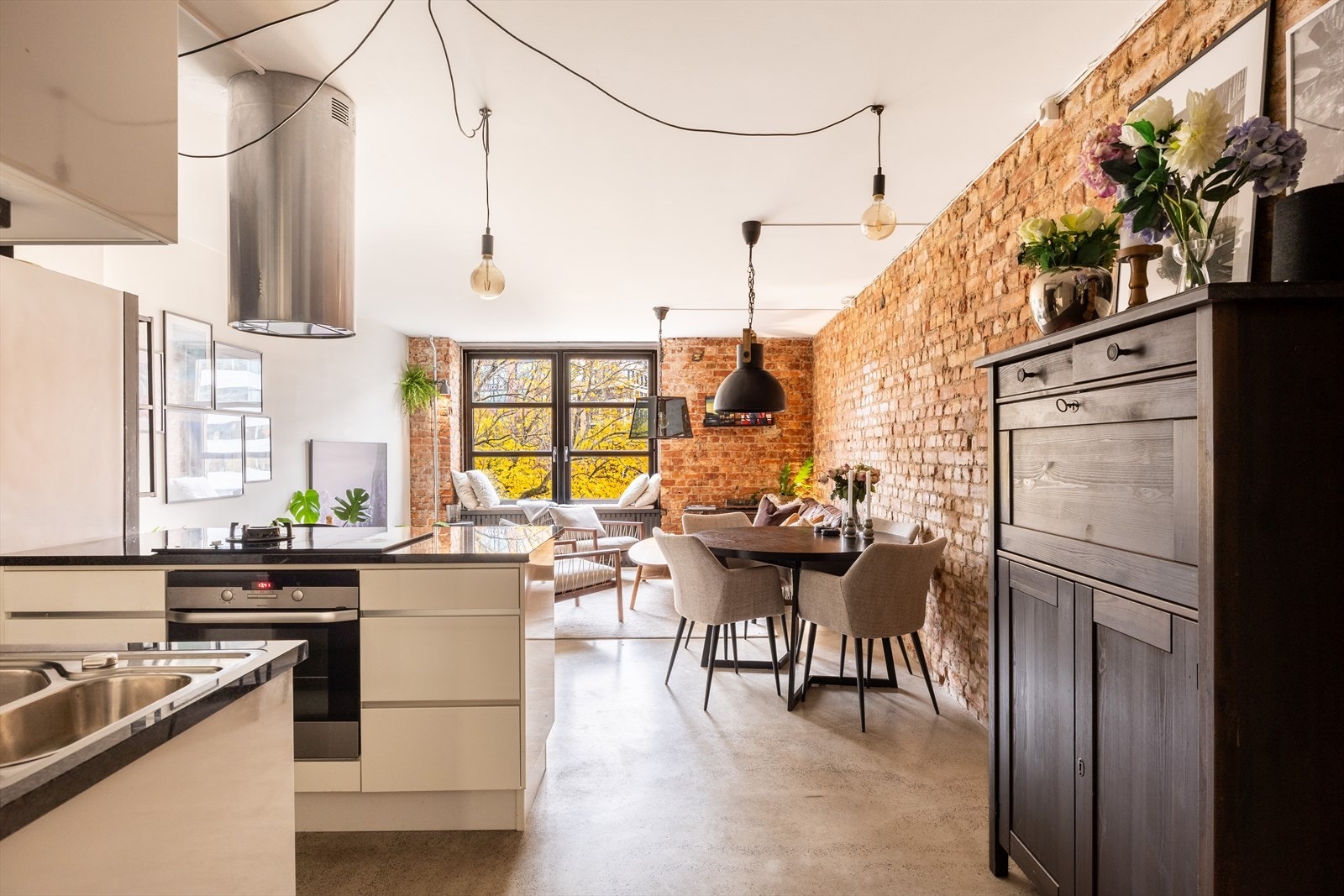 Stilig betonggulv, stort fabrikkvindu og rustikk teglstein gir leiligheten et kult særpreg. Galleribilde