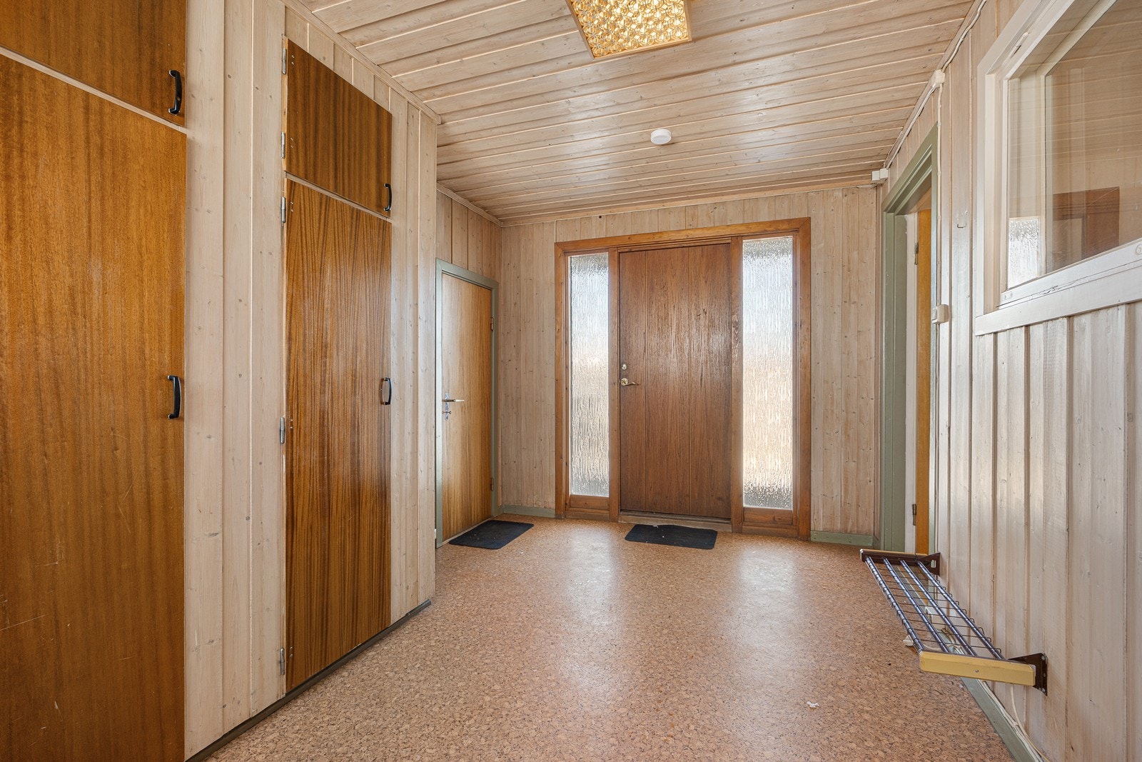 Inngangen er overbygd, og vel inne har entreen god plass til å henge fra seg yttertøyet. Her er det gulvbelegg, trepanel og innebygde garderobeskap. Galleribilde