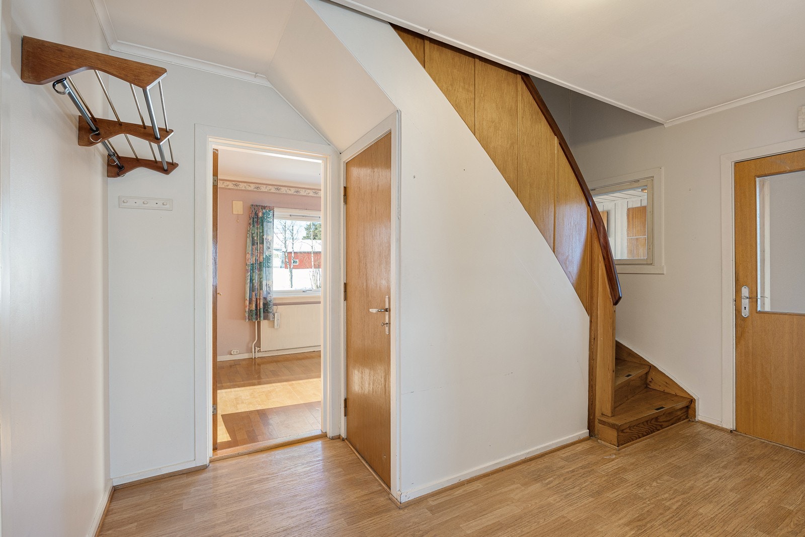 Trappeløpet til 2. etasje og kjeller er plassert i gangen innenfor entreen. Det er åpent trappeløp til 2. etasje, og dør til kjellertrappen. Galleribilde