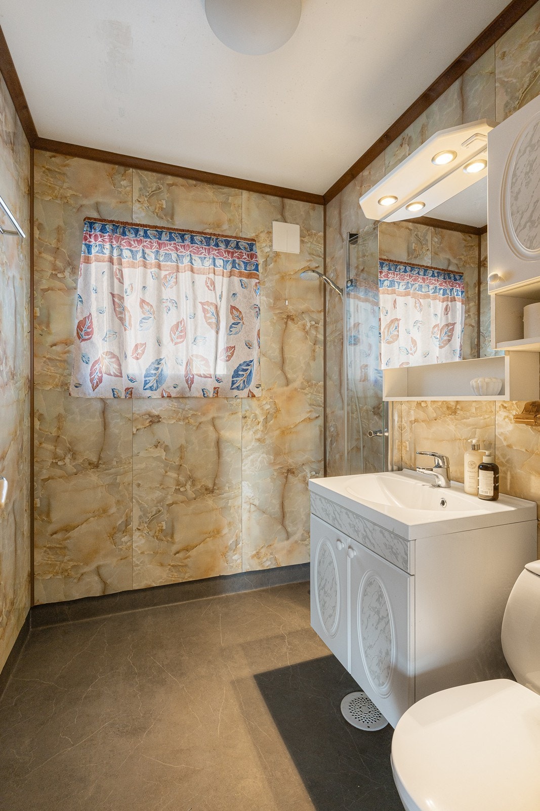 Badet er innredet med nyere gulvbelegg og mønstrede våtromsplater. Galleribilde