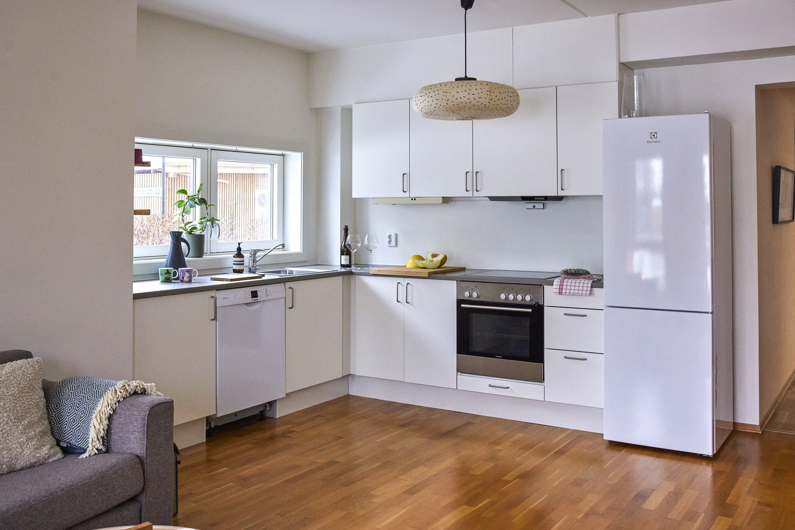 Kjøkken med åpen løsning mot stue. Kjøkkeninnredning med glatte fronter og benkeplate av laminat. Galleribilde