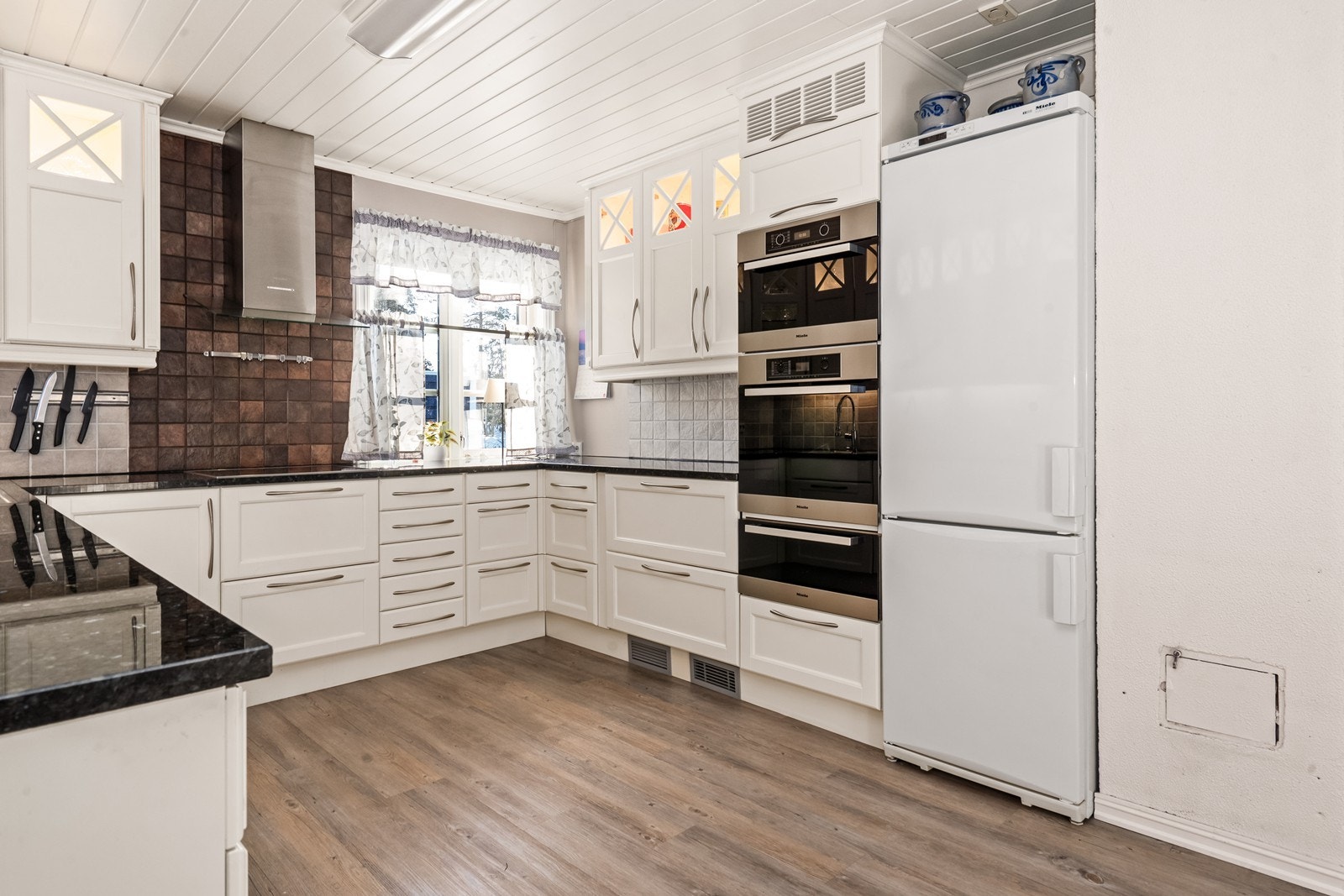 Kjøkkenet er utstyrt med fliser mellom skapene og en nedsenket vask i rustfritt stål. Galleribilde