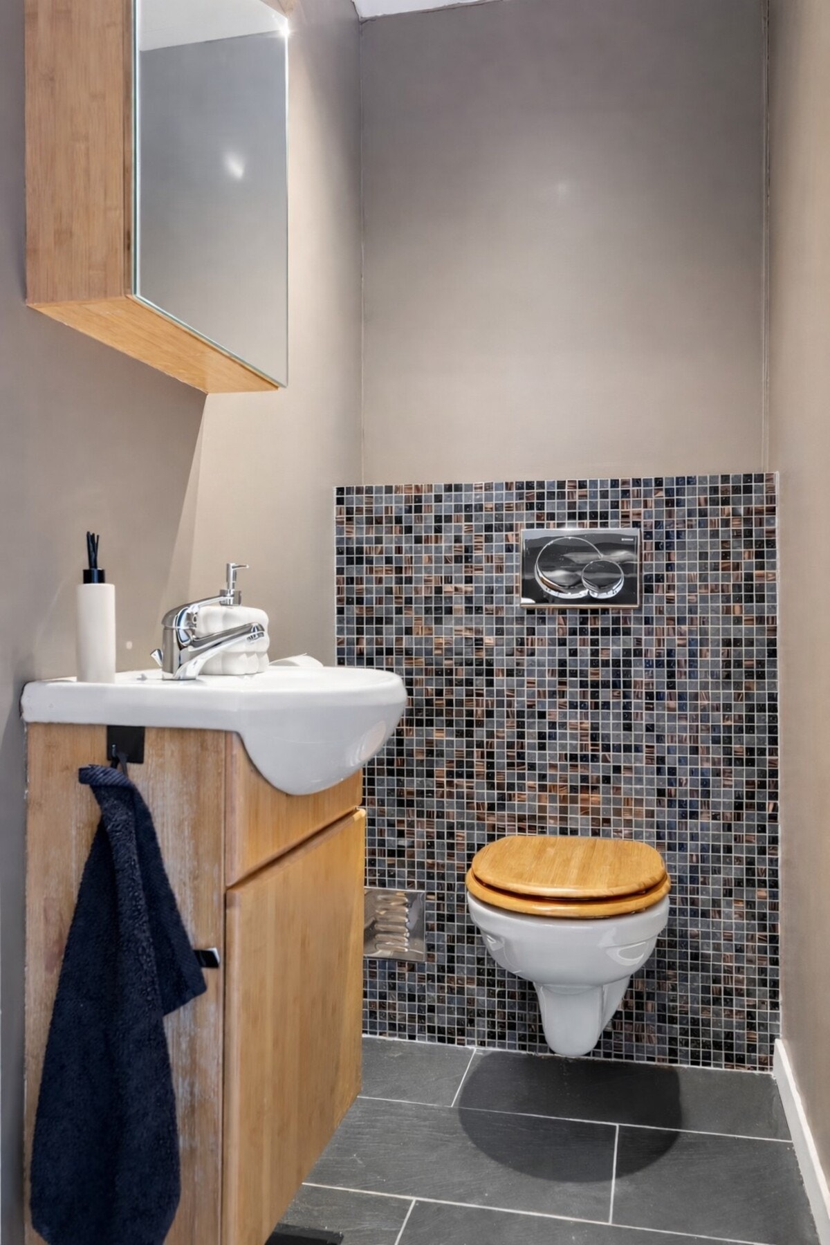 Det separate toalettrommet har flislagt gulv, malte vegger og himling, vegghengt toalett og servantinnredning, samt mekanisk avtrekk. Galleribilde