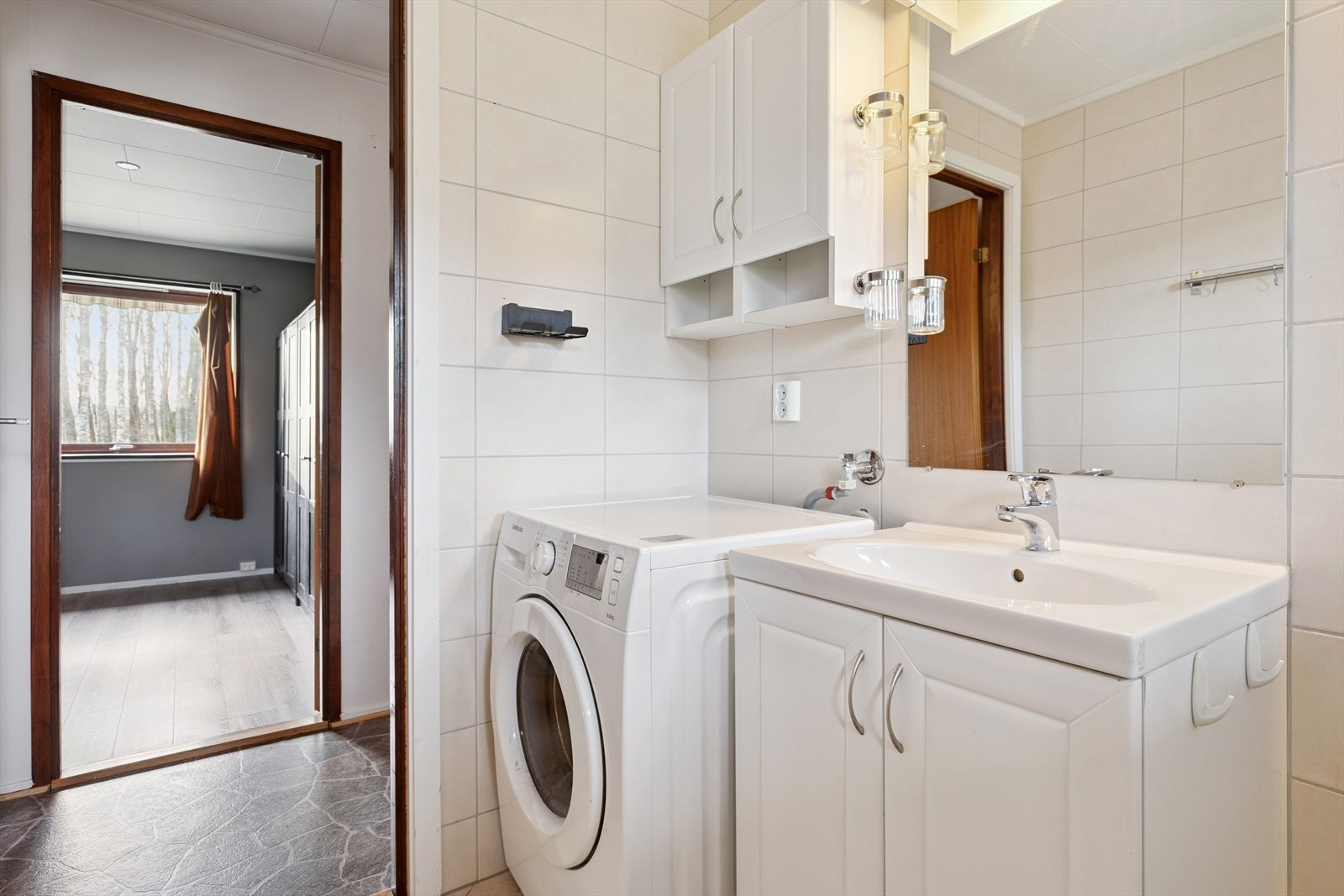 Badet ble pusset opp i 2015 og har flislagte overflater, servantinnredning og opplegg for vaskemaskin. Galleribilde