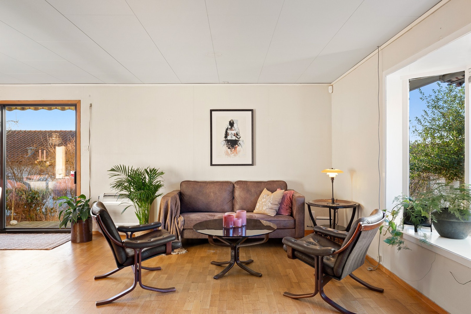 Store vindusflater på to sider gir rikelig med naturlig lys, og skyvedør leder ut til hyggelige uteområder. Galleribilde