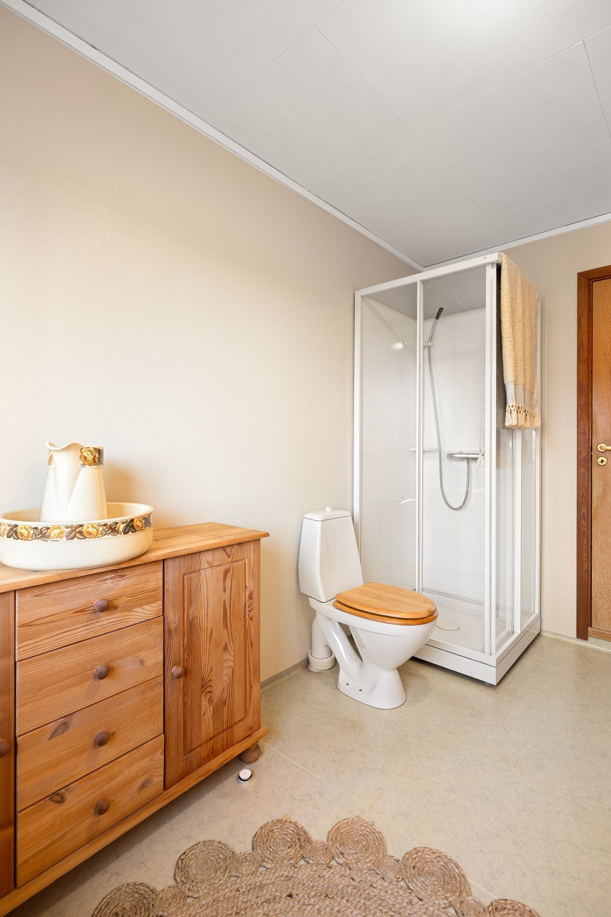 Det er innredet med hvit baderomsinnredning med nedfelt servant og overskap med speil, samt dusjkabinett og gulvmontert toalett. Galleribilde