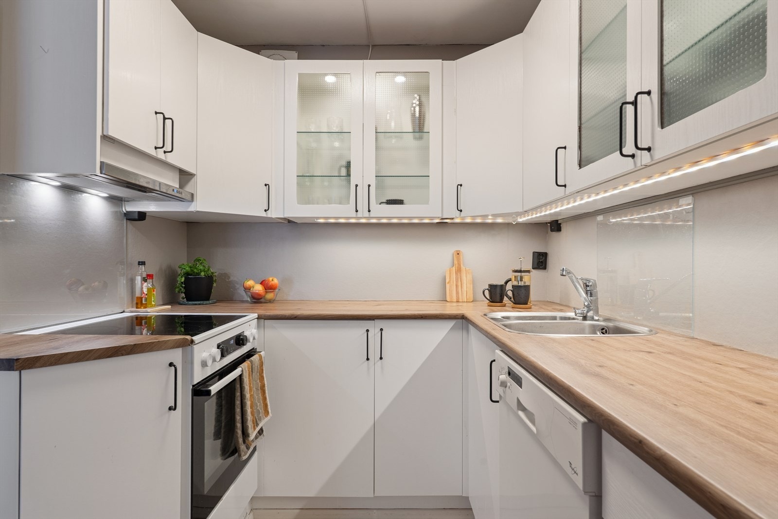 Lys og tidløst kjøkken med alt en måtte trenge av skap-, skuff- og benkeplass. Her får kokken gode arbeidsforhold. Galleribilde